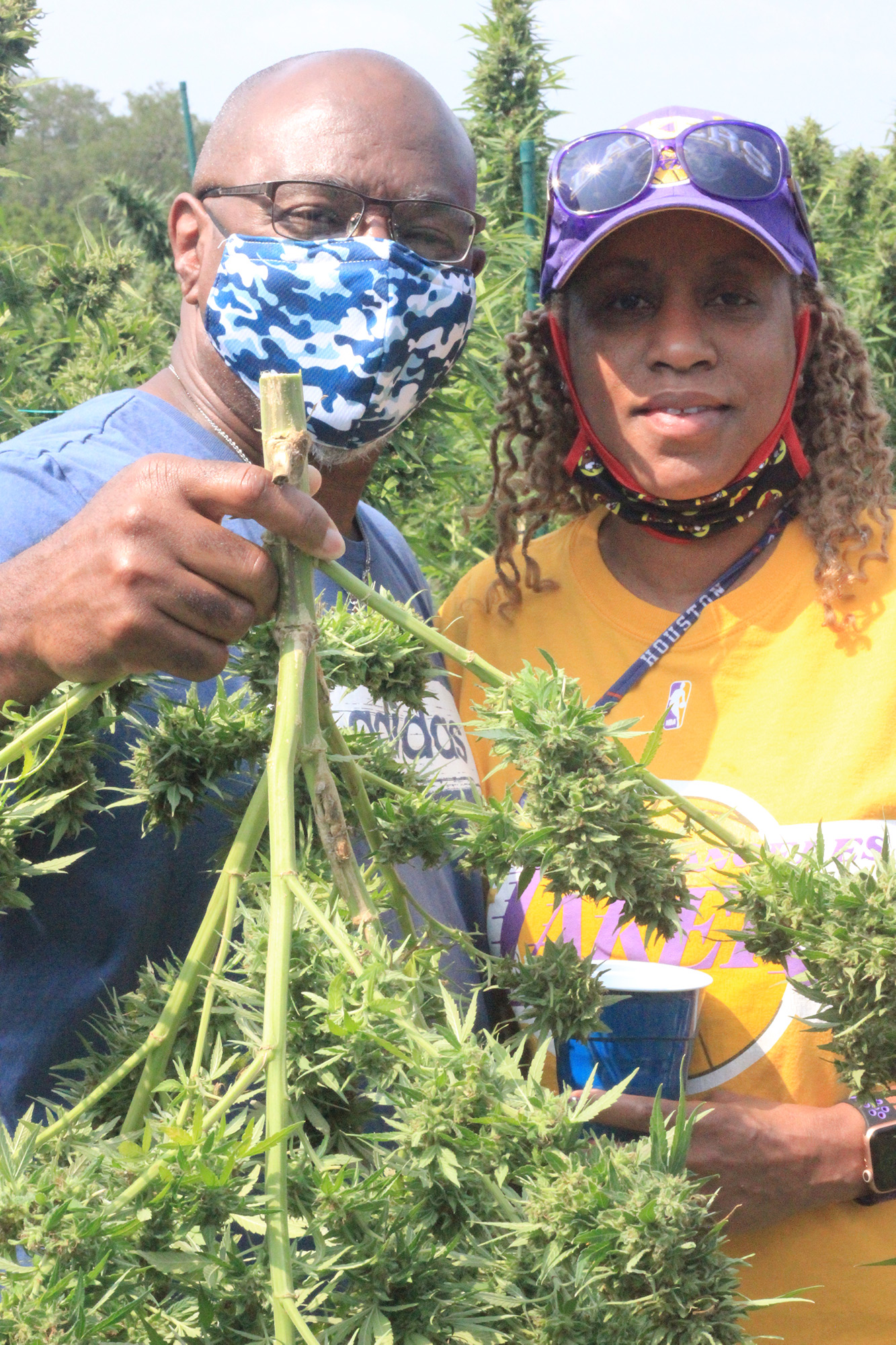 visitors to the hemp farm holding a piece of a hemp plant