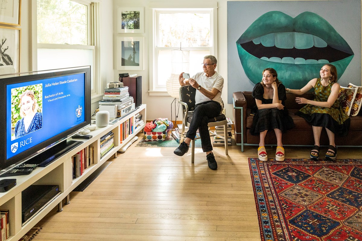 A family sits in their living room and watches a Rice University graduation ceremony on tv.