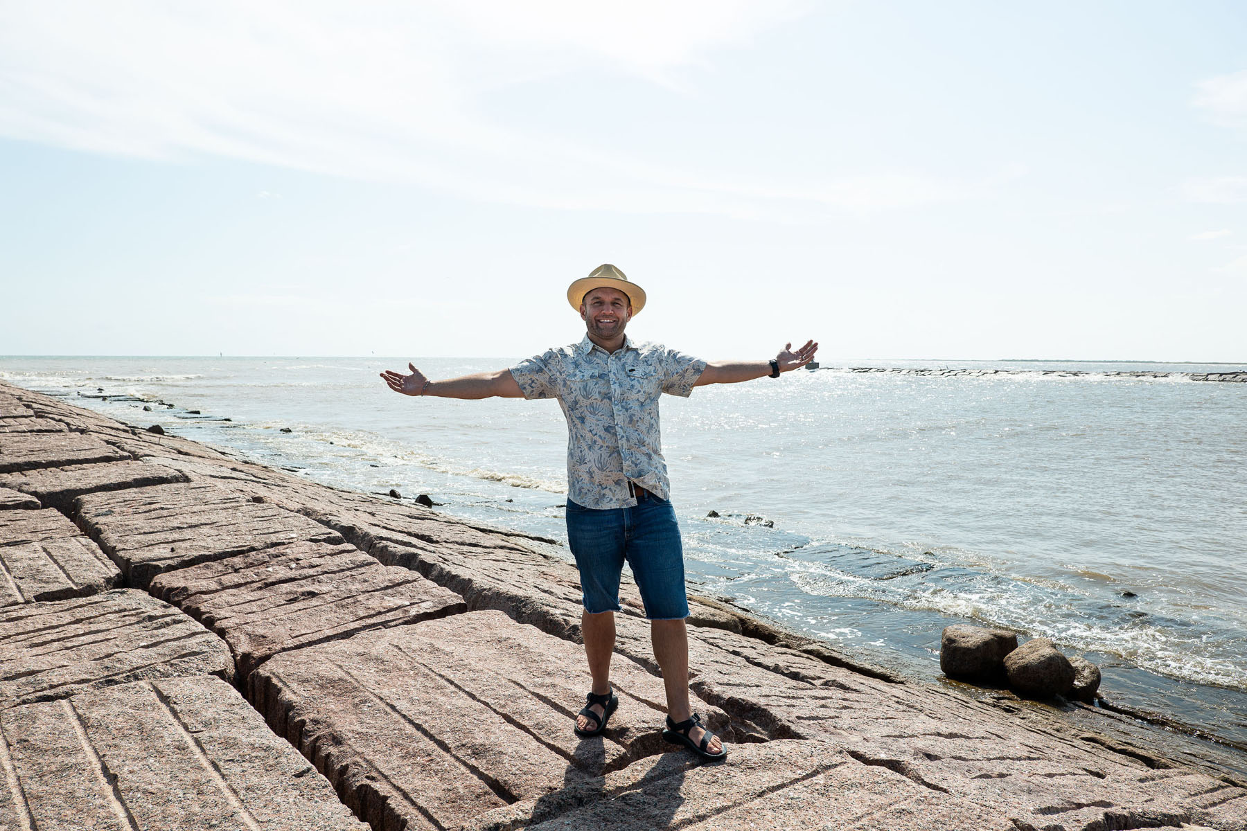 Chet Garner stands in front of the Gulf of Mexico in a small sombrero and floral shirt