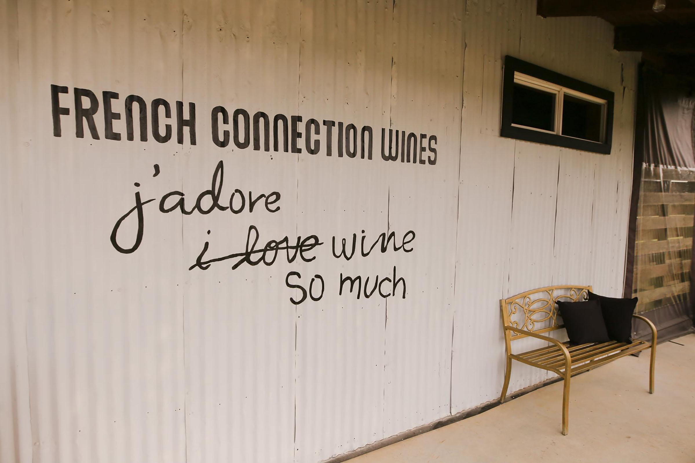 A wall at French Connection Wines with the words 'J'adore wine so much' written on it. 