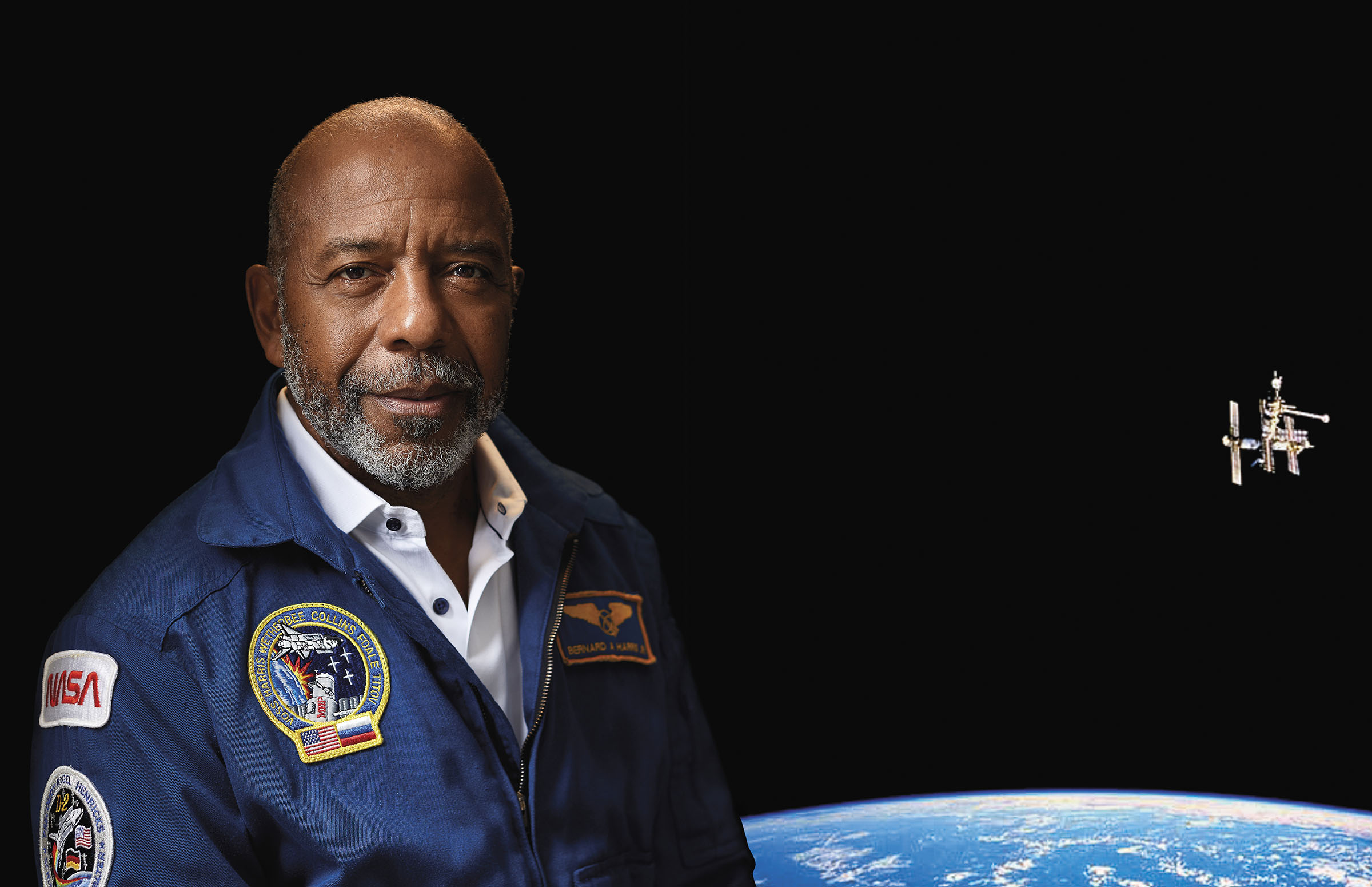 Bernard Harris, Jr. in a NASA uniform with a scenic view of Mir during Mission STS-63