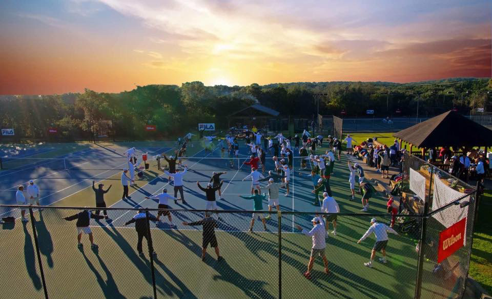 Rows of campers get ready for tennis with early morning stretch session at Tennis Fantasies with John Newcombe and the Legends. Courtesy of Tennis Fantasies with photos by Ken Munson Photography.