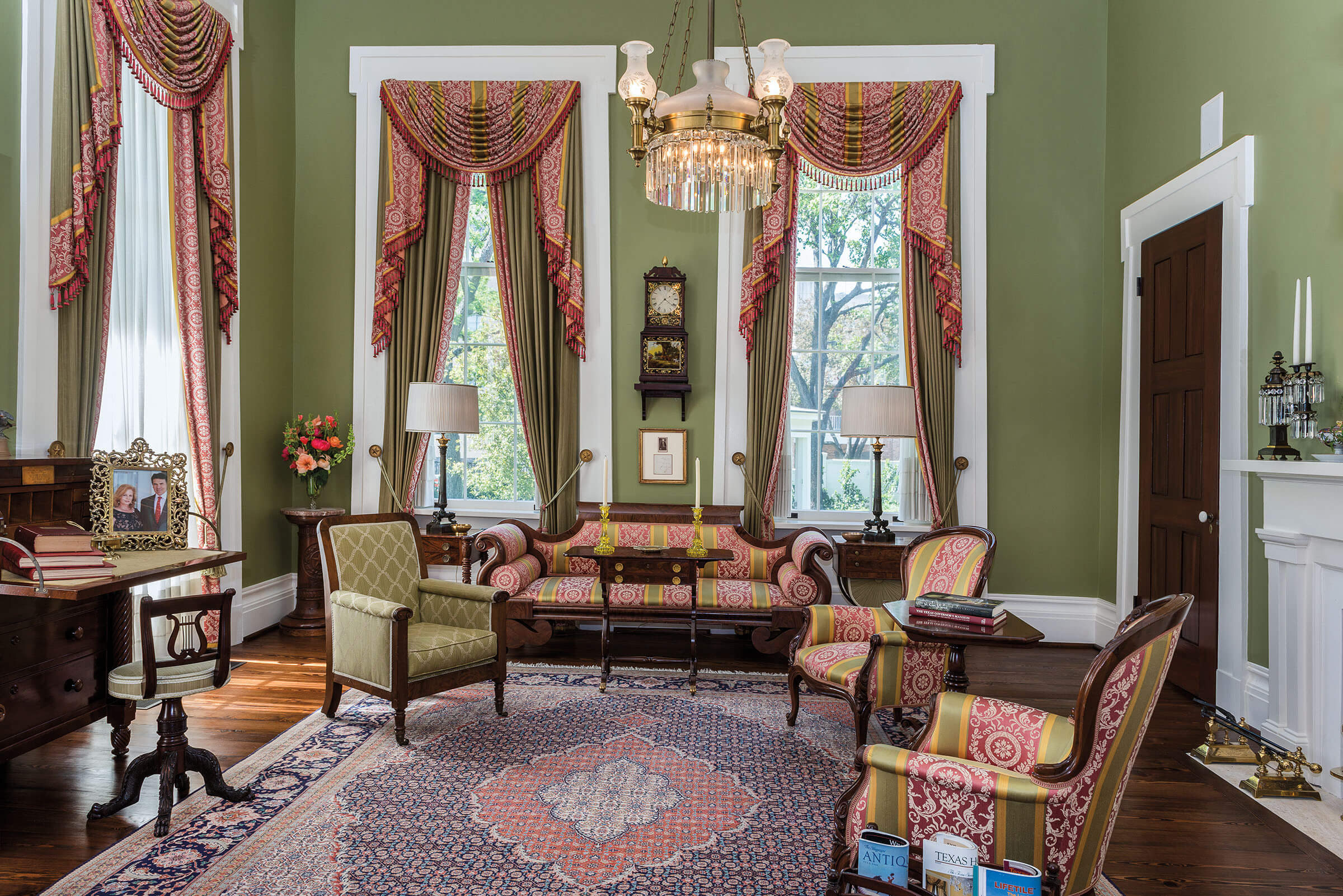 The posh interior of the Governor's Mansion with green walls, pink curtains and armchairs