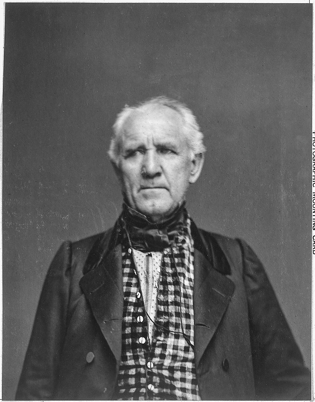 A black and white portrait of Sam Houston in a jacket and checkered shirt