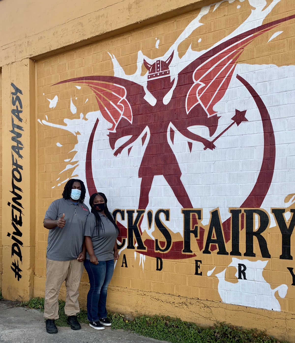 Black's Fairy Meadery co-owners Calvin Greene and Terica Groves photographed at their meadery, standing next to a mural on the outside of the building.