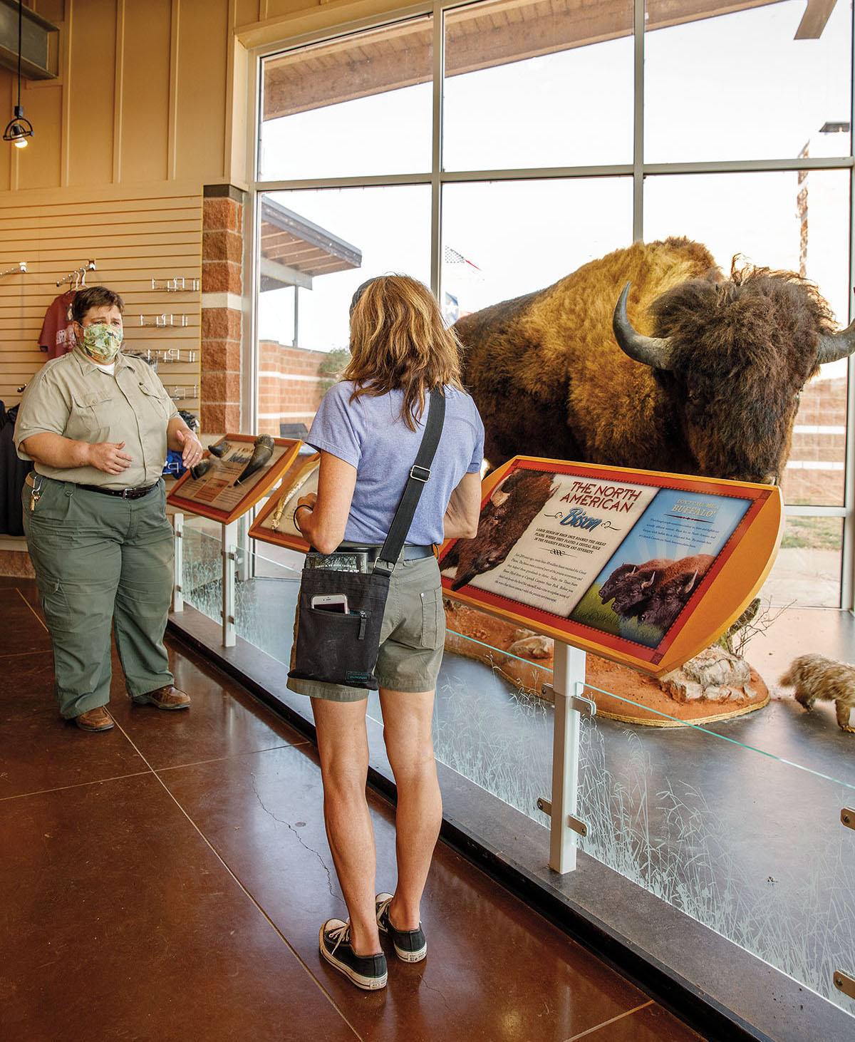 An interpretaive ranger speaks with a guest inside a visitor center at Caprock Canyons state Park