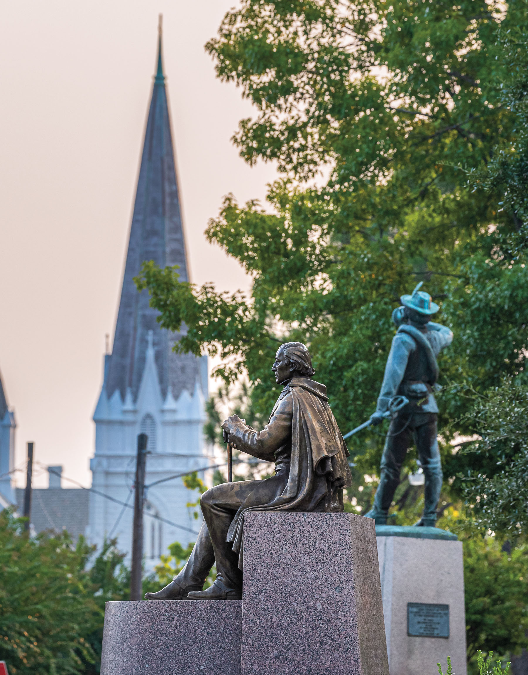 A pink sky behind a Statue of Jose Antonio Navarro in front of Navarro County Courthouse