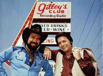 Musicians Johnny Lee (left) and Mickey Gilley stand under the sign outside the famous Pasadena honky-tonk Gilley's. Photo courtesy Third Coast Talent. 