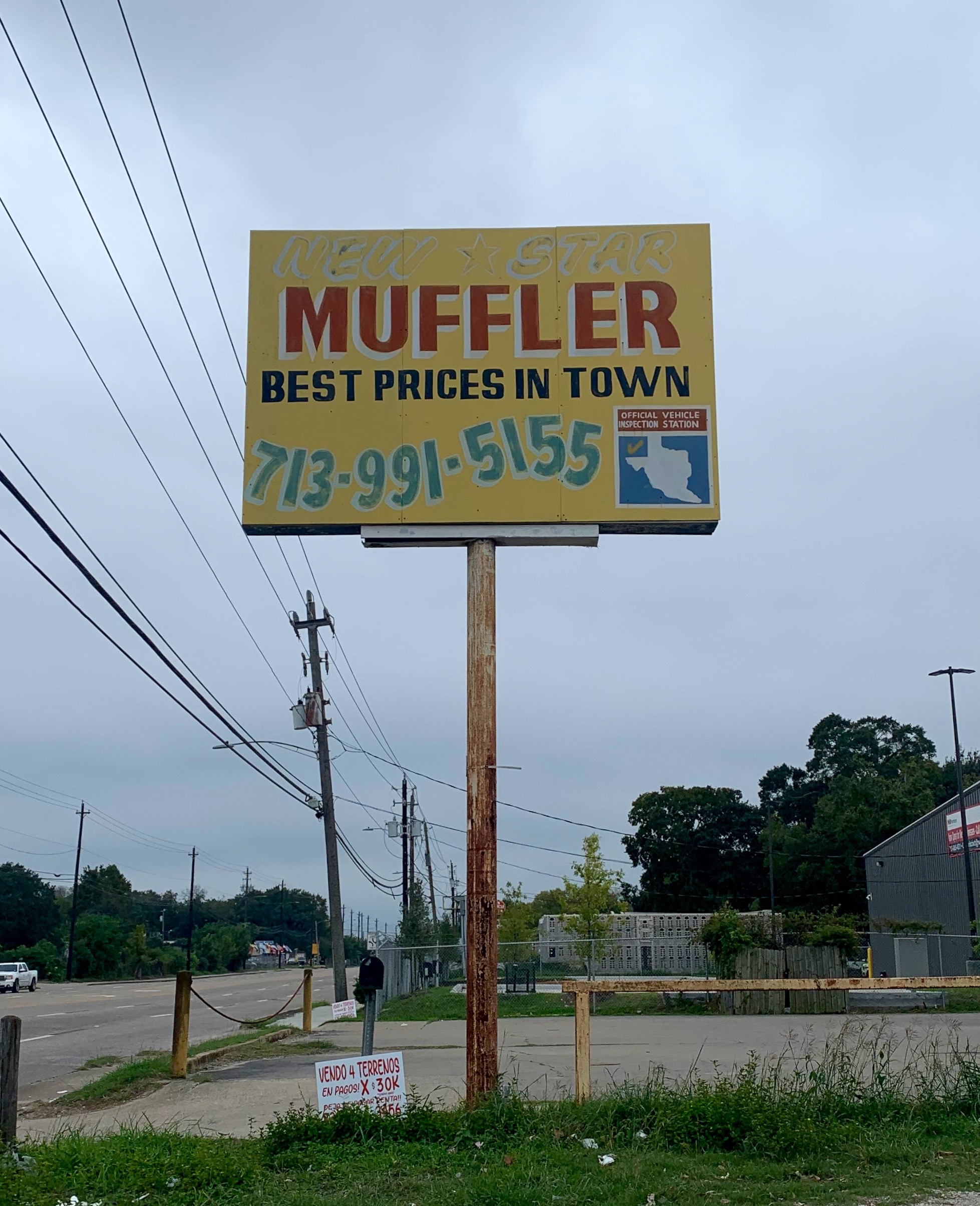 A mechanics shop sign on Telephone Road, with the word Muffler and a state inspection signage.