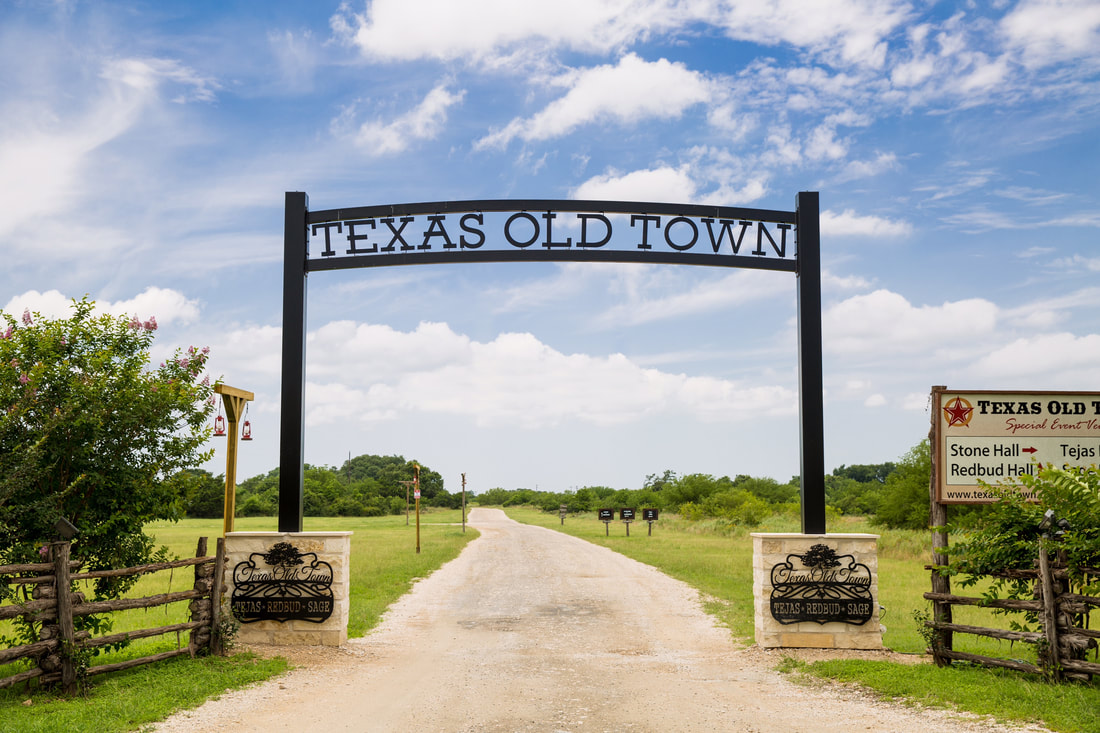 A metal works sign saying Texas Old Town at the entrance of a ranch. 