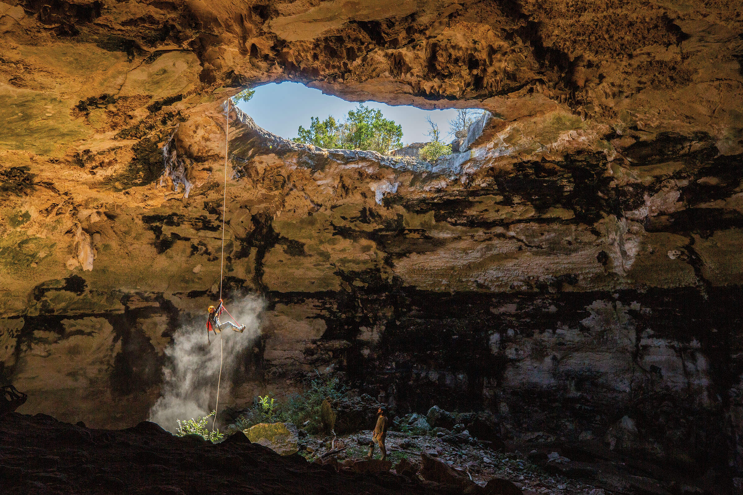 A caver ascends out of Punkin Cave