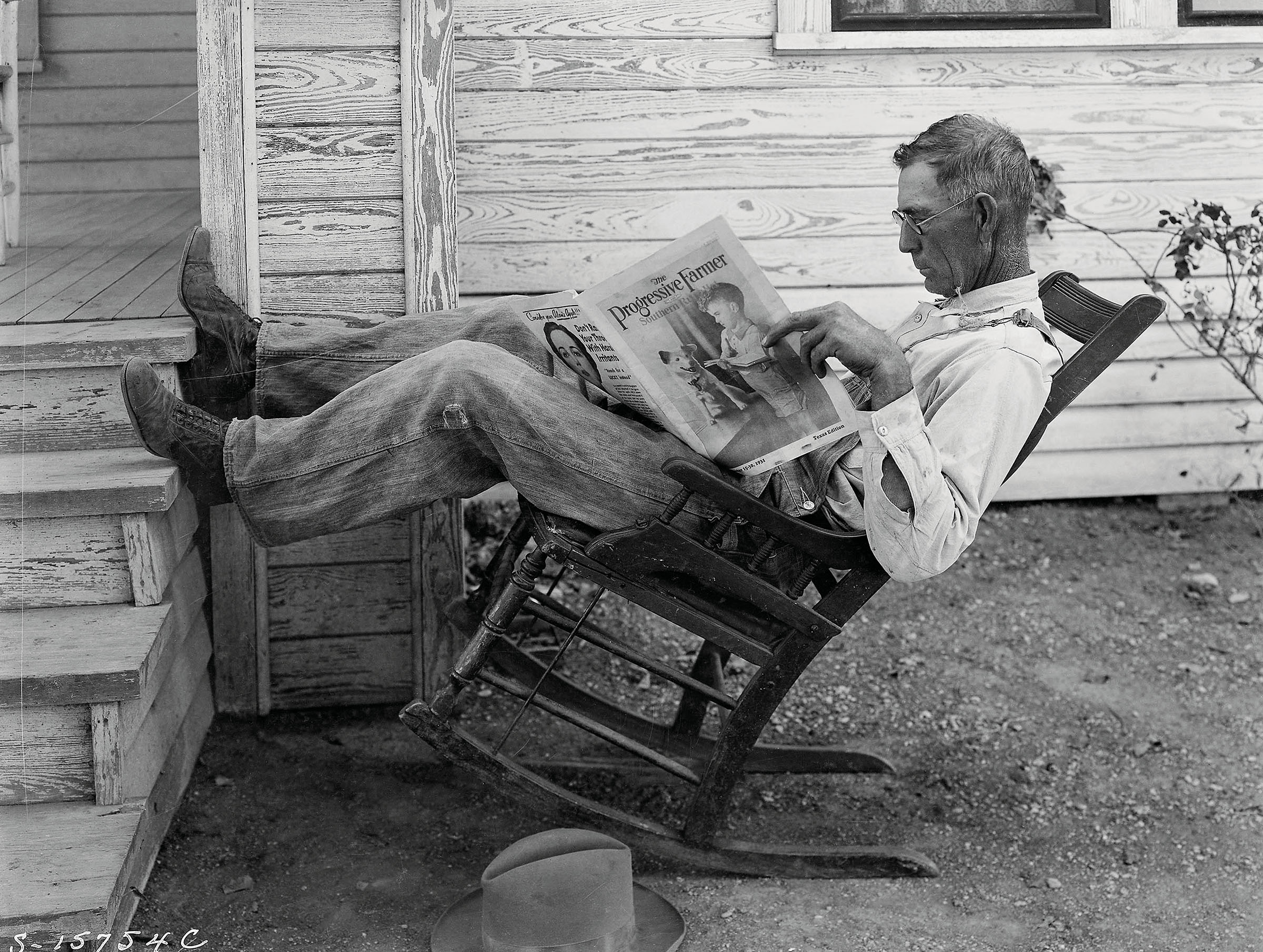 A Coryell County farmer in 1931 reads a newspaper outside