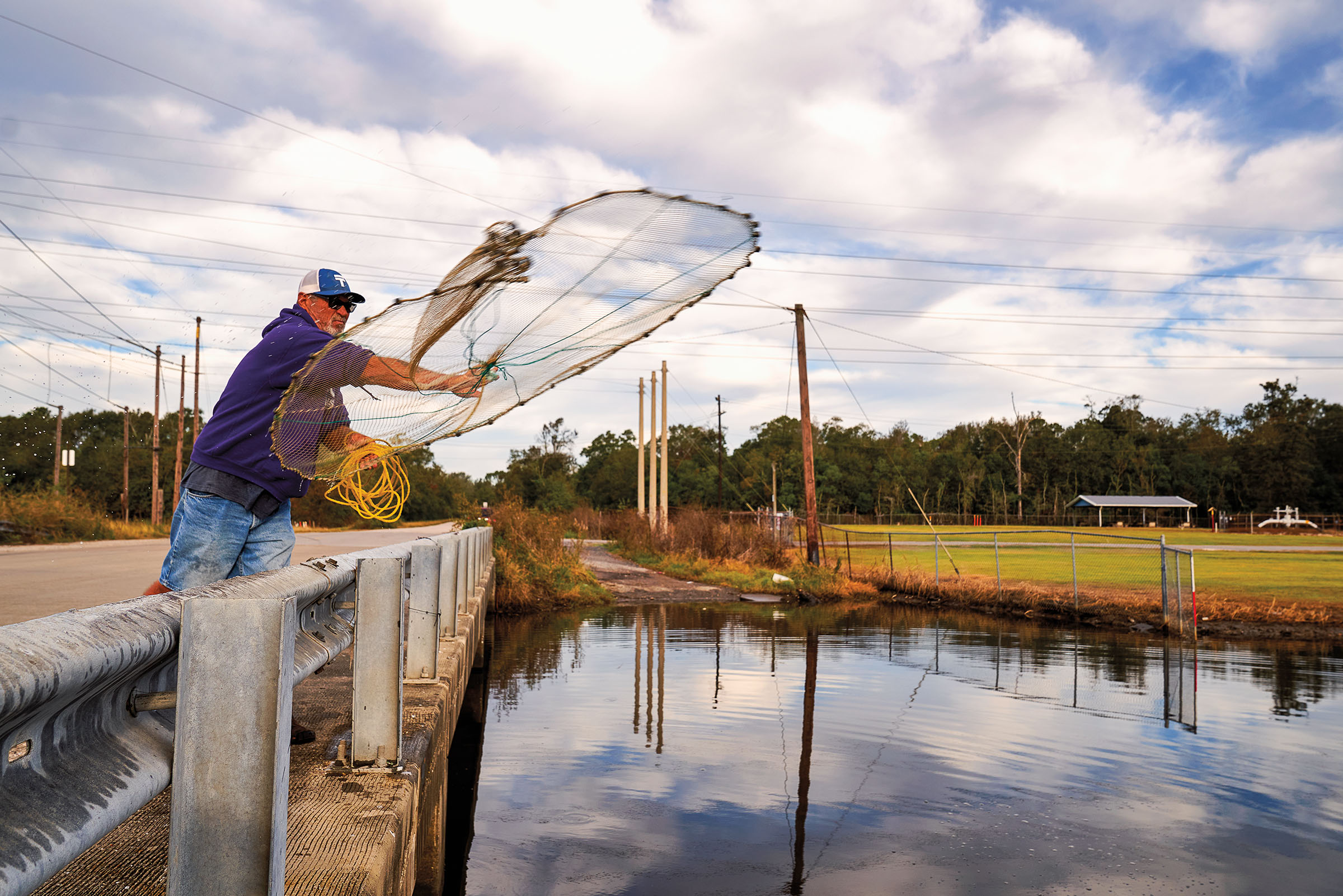 A man throws a large net over a body of water