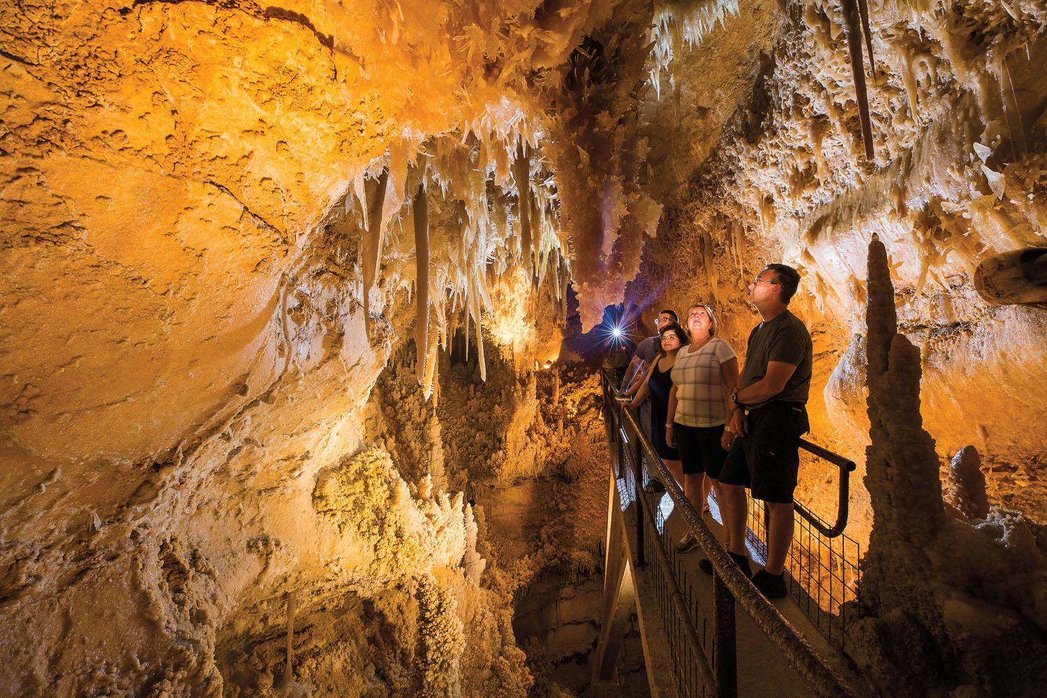 People stand under sharp points in a cave