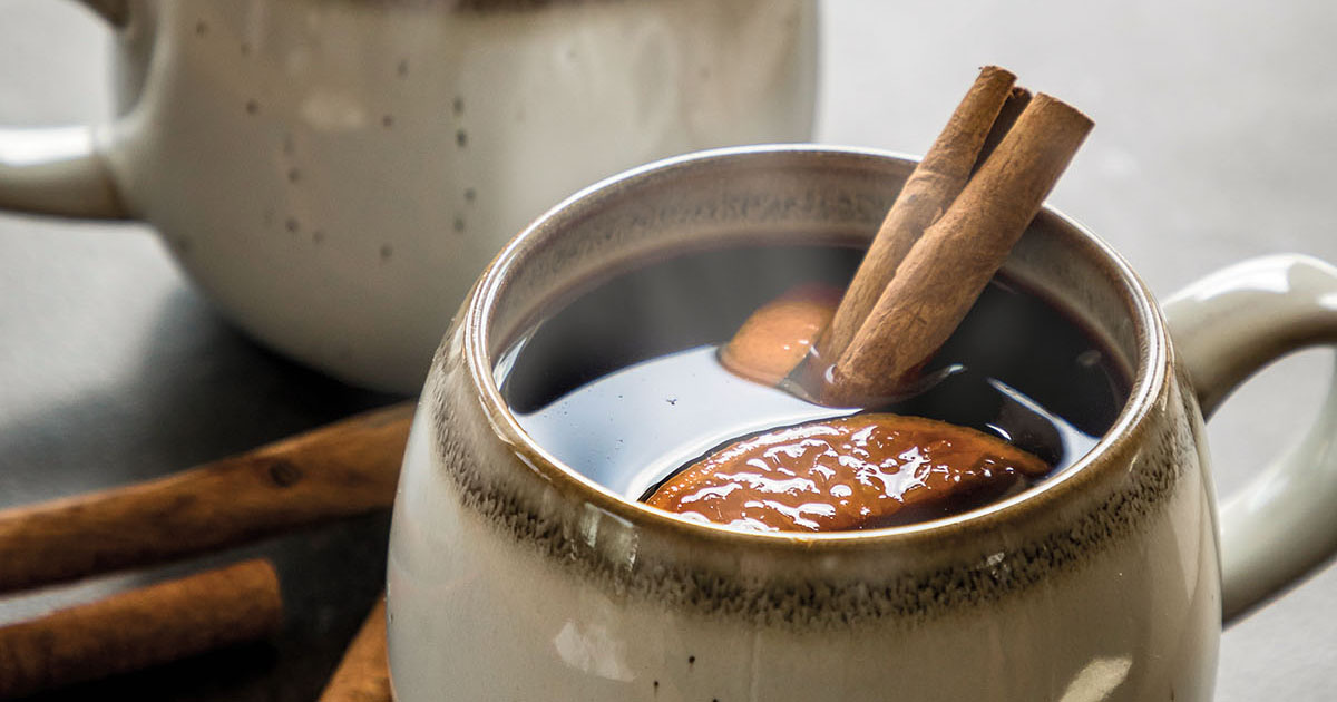 A steaming cup of gluhwein with a cinnamon stick
