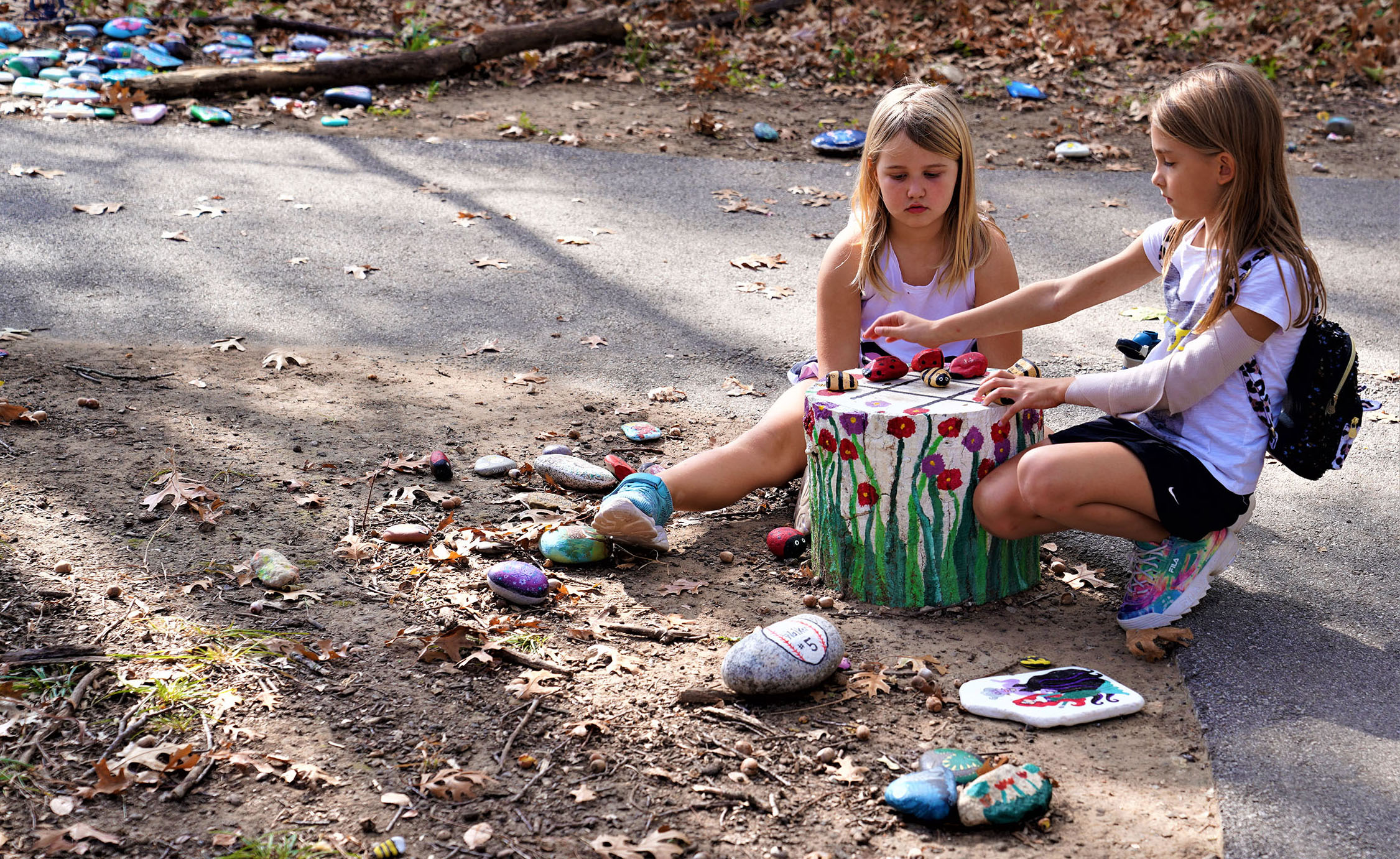 Two little girls sit among some of the art rocks in Parr Park. Photo courtesy of Ron Olsen. 