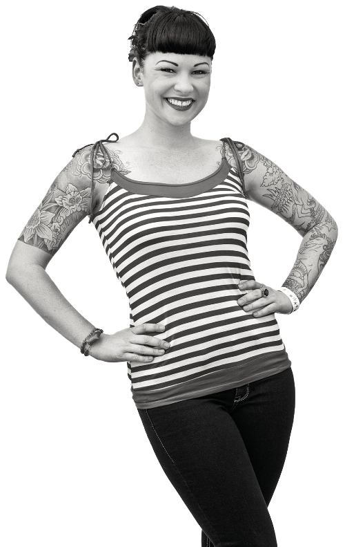 A woman in a striped shirt poses with her hands on her hips