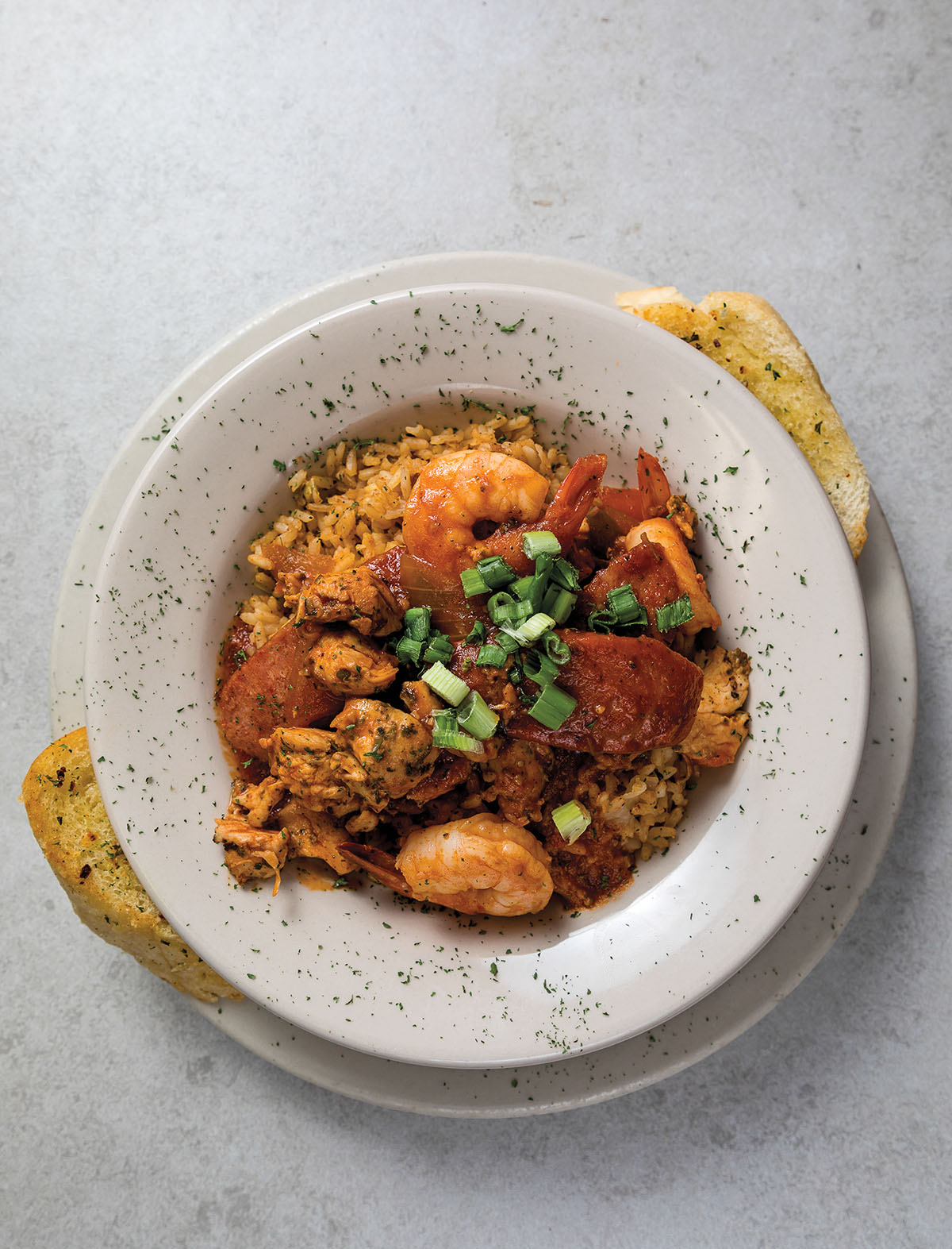 An overhead view of a plate of jambalaya in a white bowl