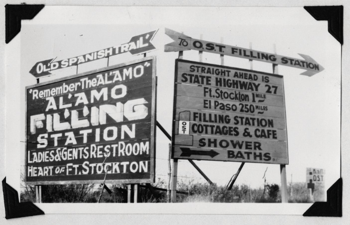 A historic photograph of billboards reading 