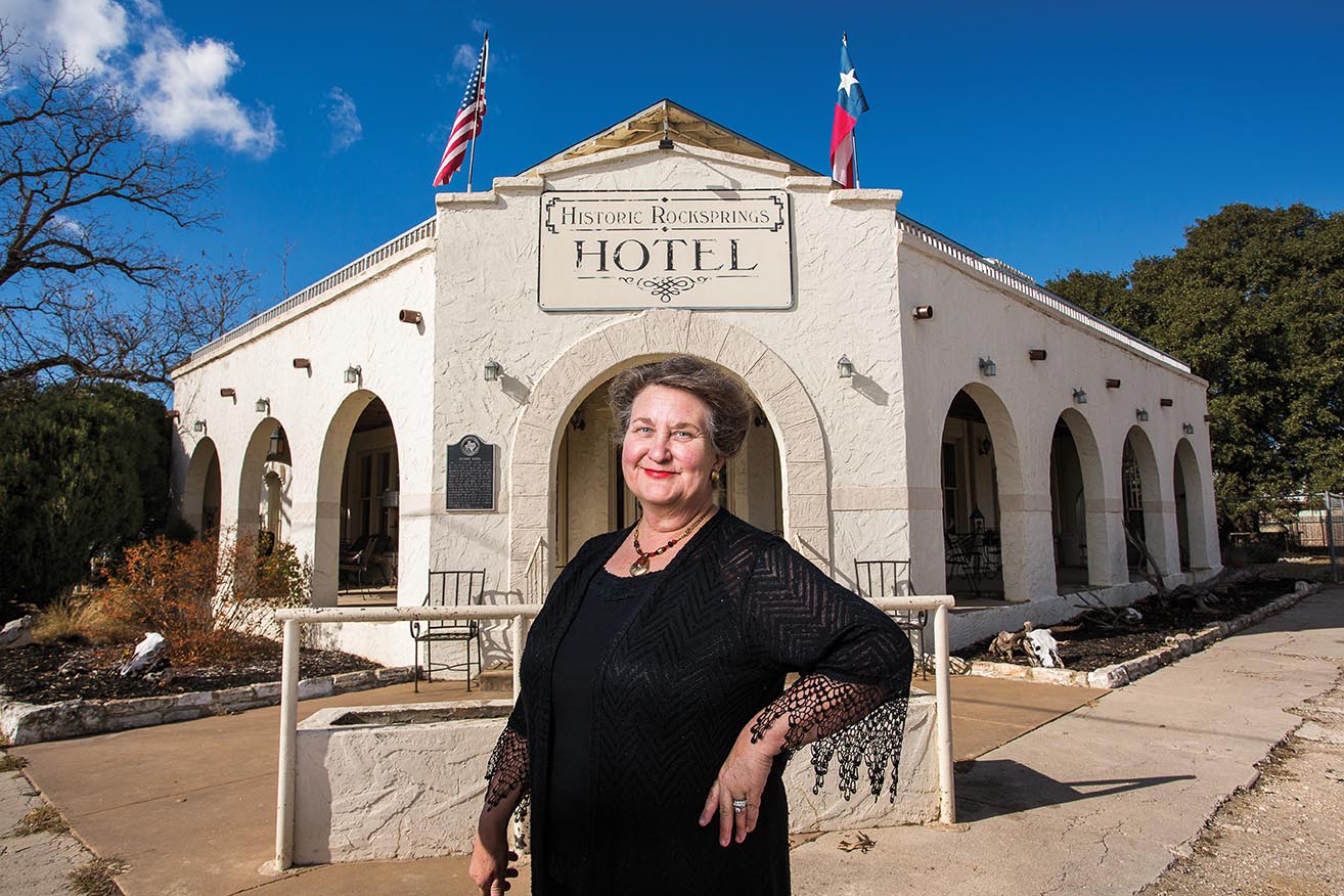 Debra Wolcott stands in front of the Historic Rocksprings Hotel, which she owns and operates.