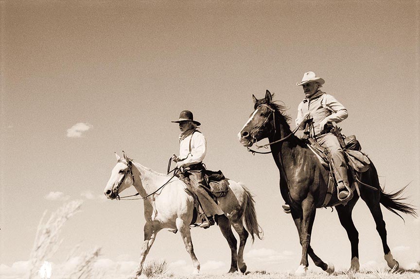 Actors Tommy Lee Jones (on the left) and Robert Duvall as their characters Call and Gus ride horses in this black and white photo title 'On the Mesa.' Photo by Bill Wittliff in 1988. 