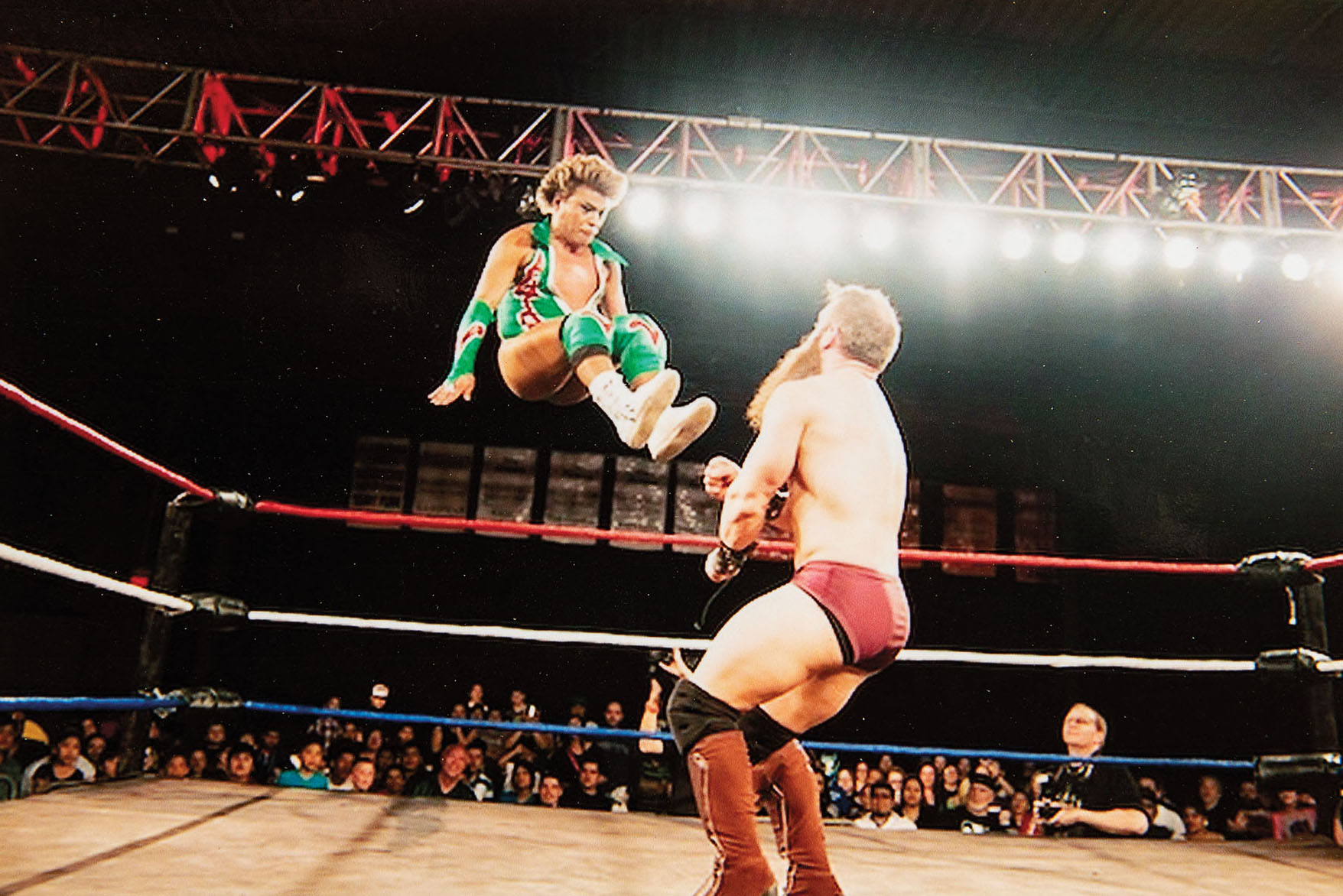 Two people in a lucha libre ring undeer bright white lights