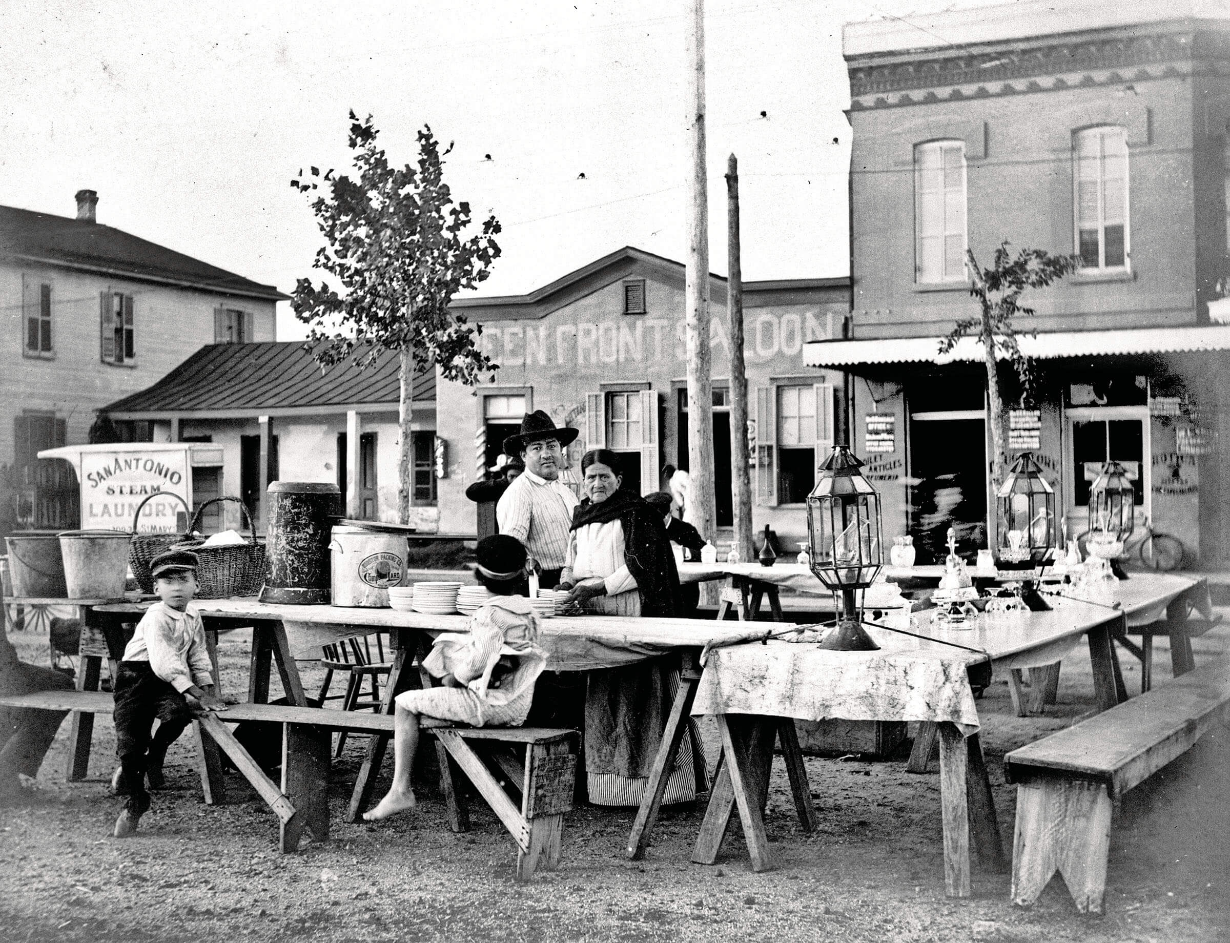 A black-and-white photo of people seated at picnic tables outside