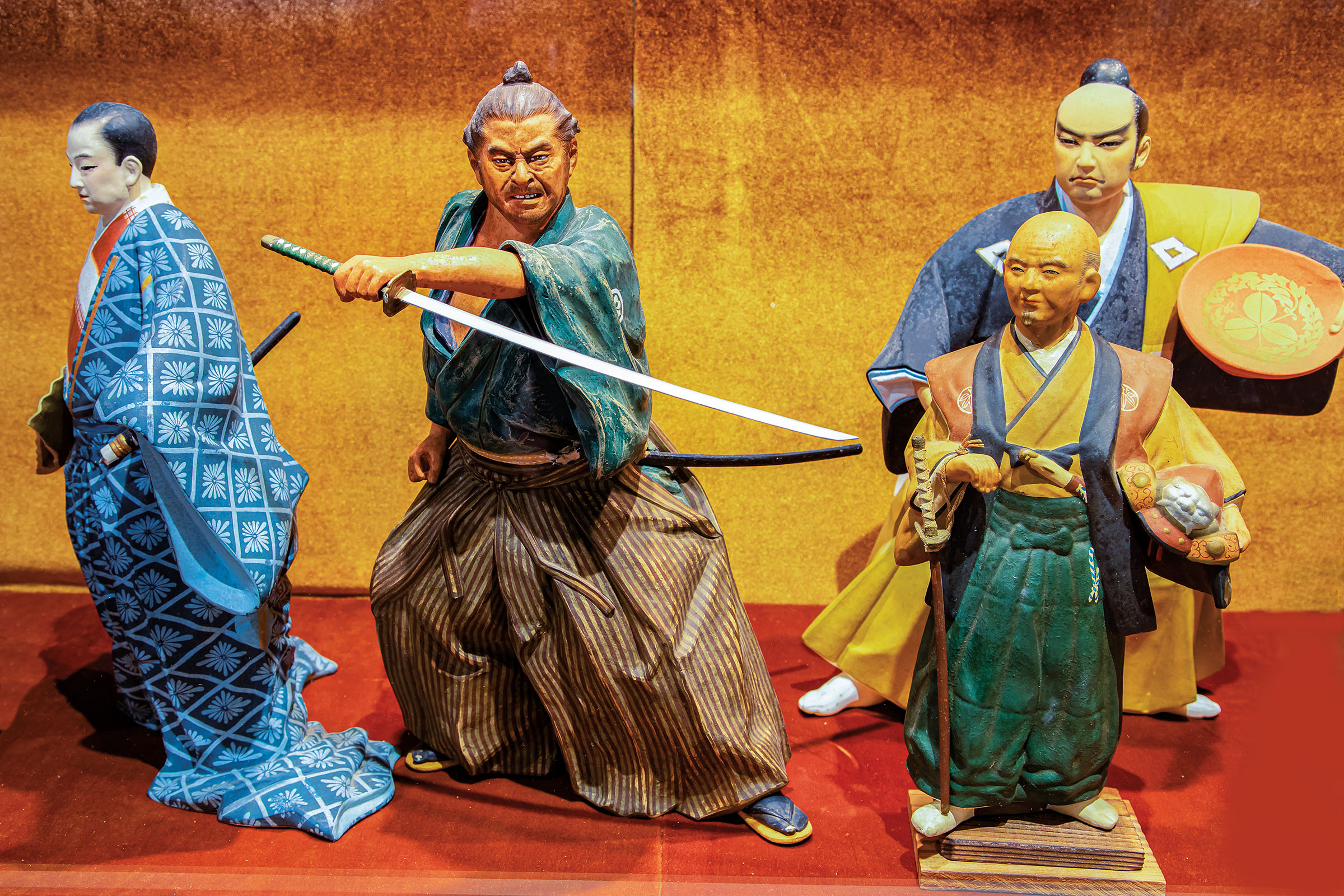 A group of brightly-colored figurines, one holding a wide sword