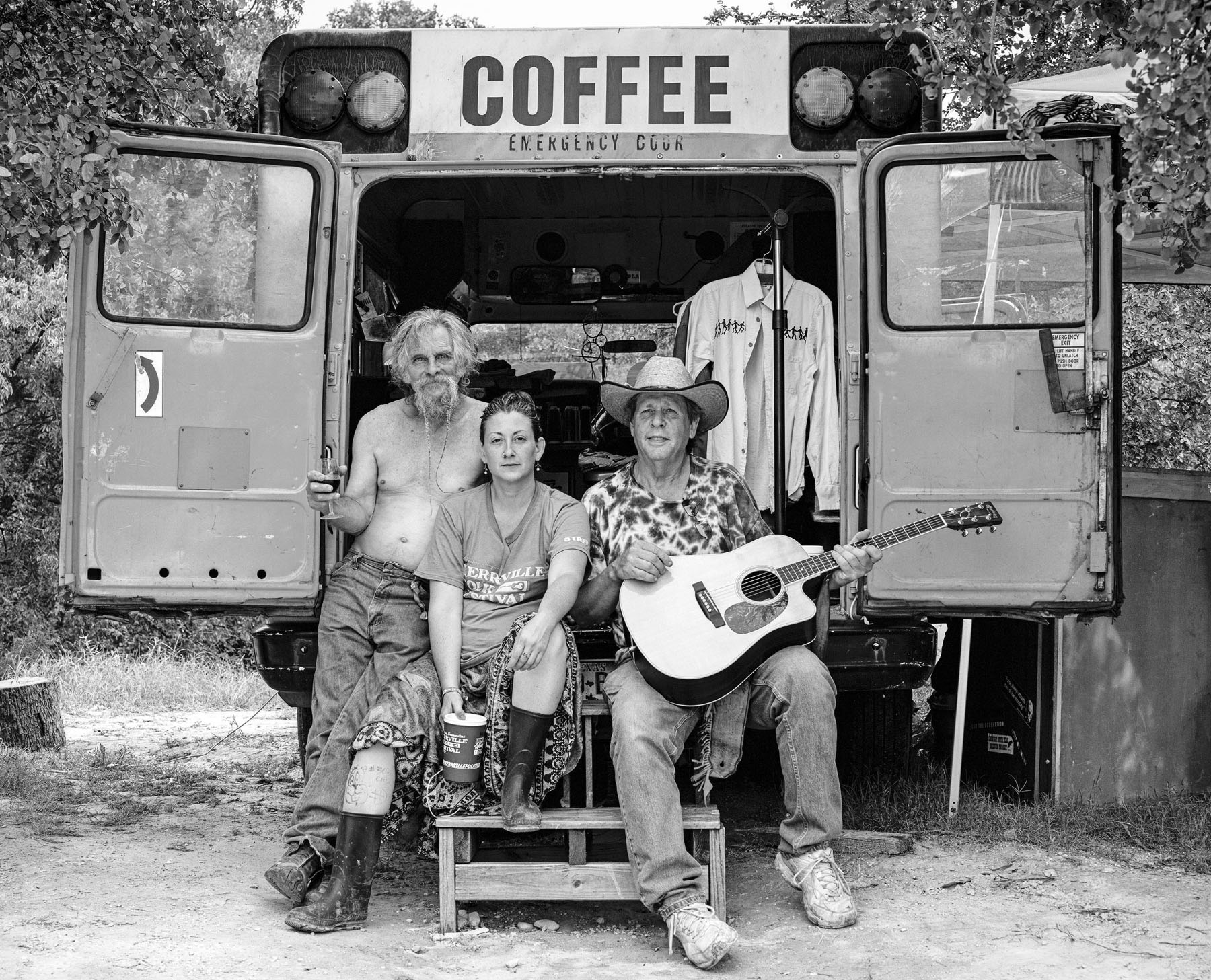 A group of men sit in the back of a bus marked "COFFEE"