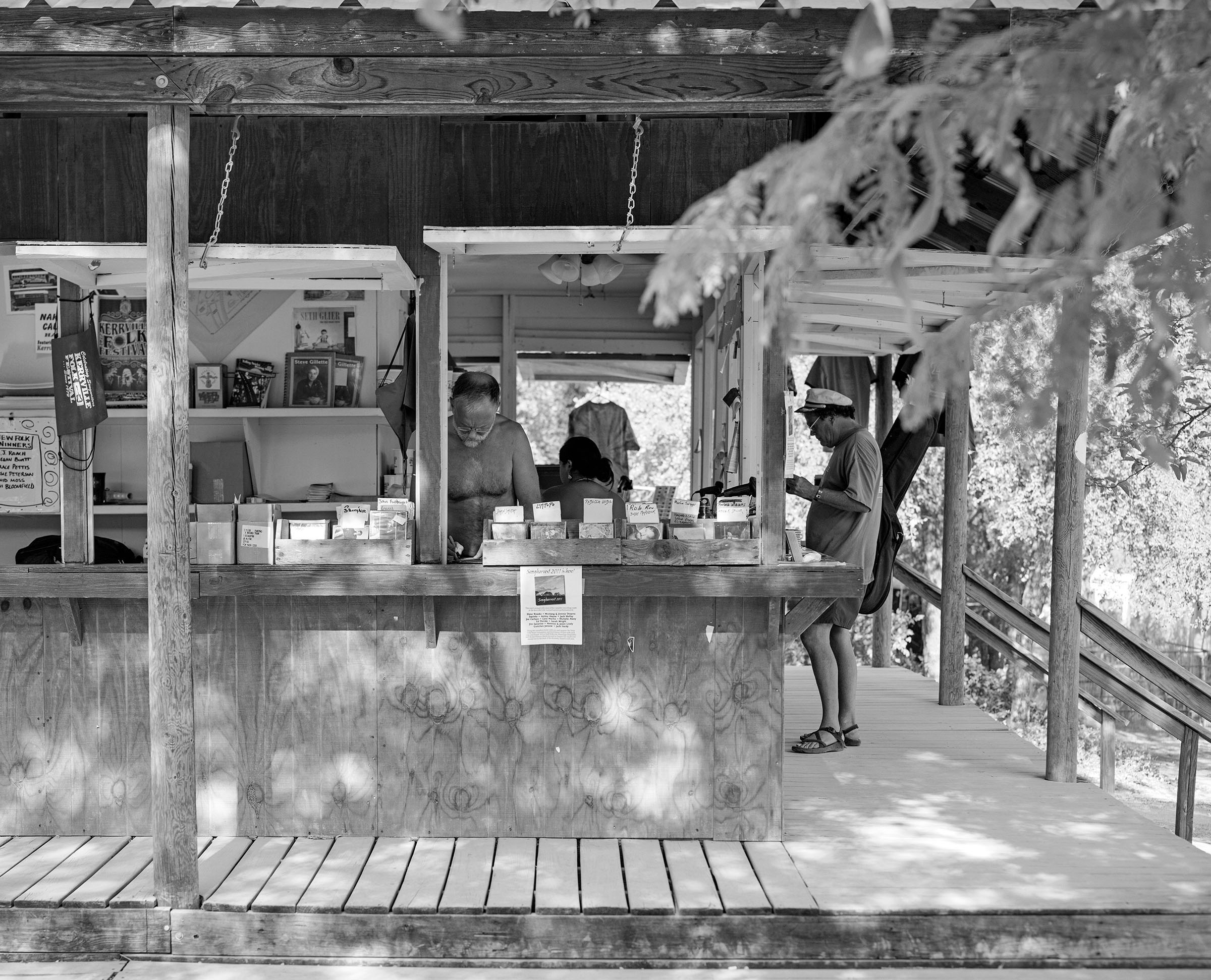 A black and white photo of merchandise set out at a festival