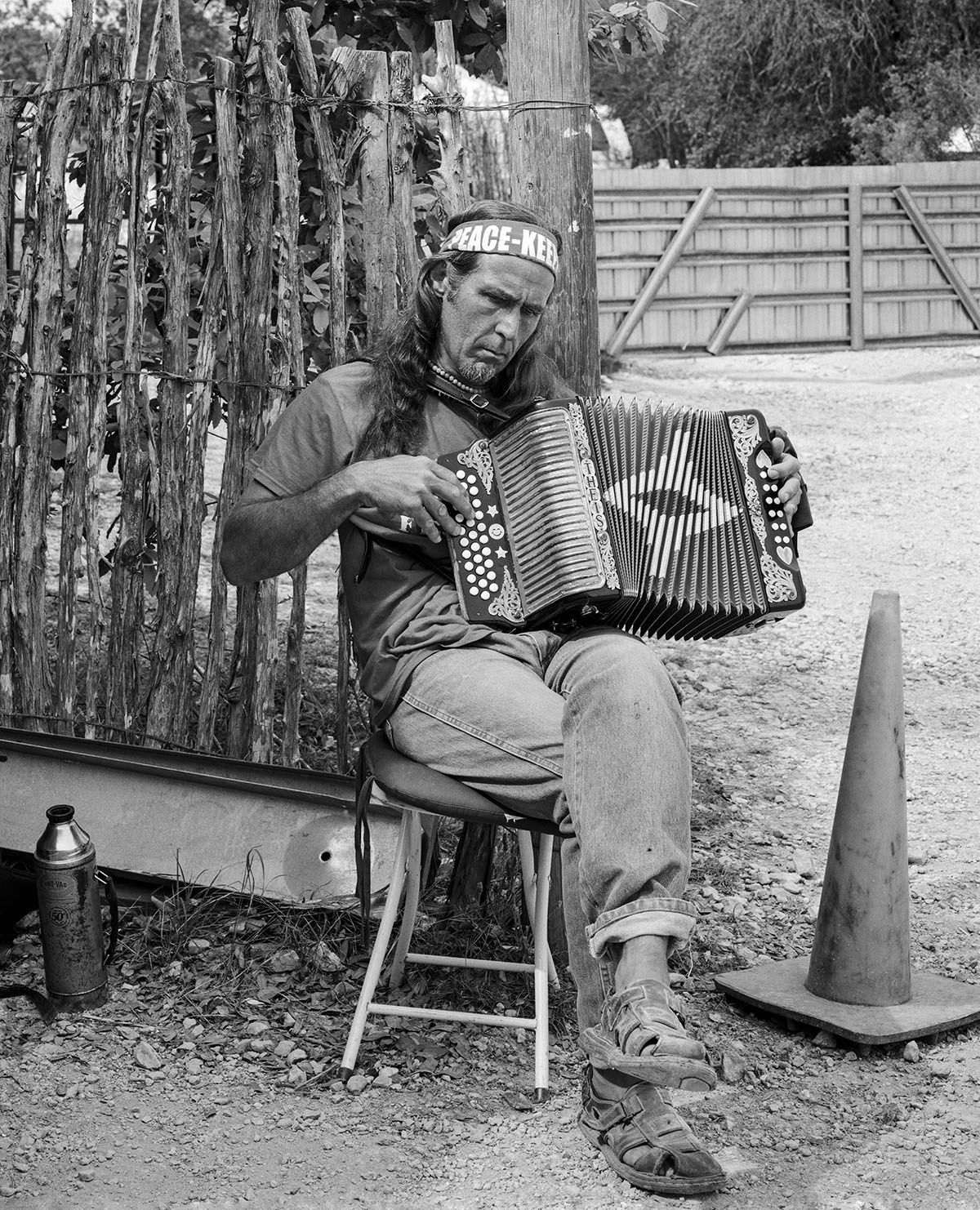 A man wearing a headband plays the accordion