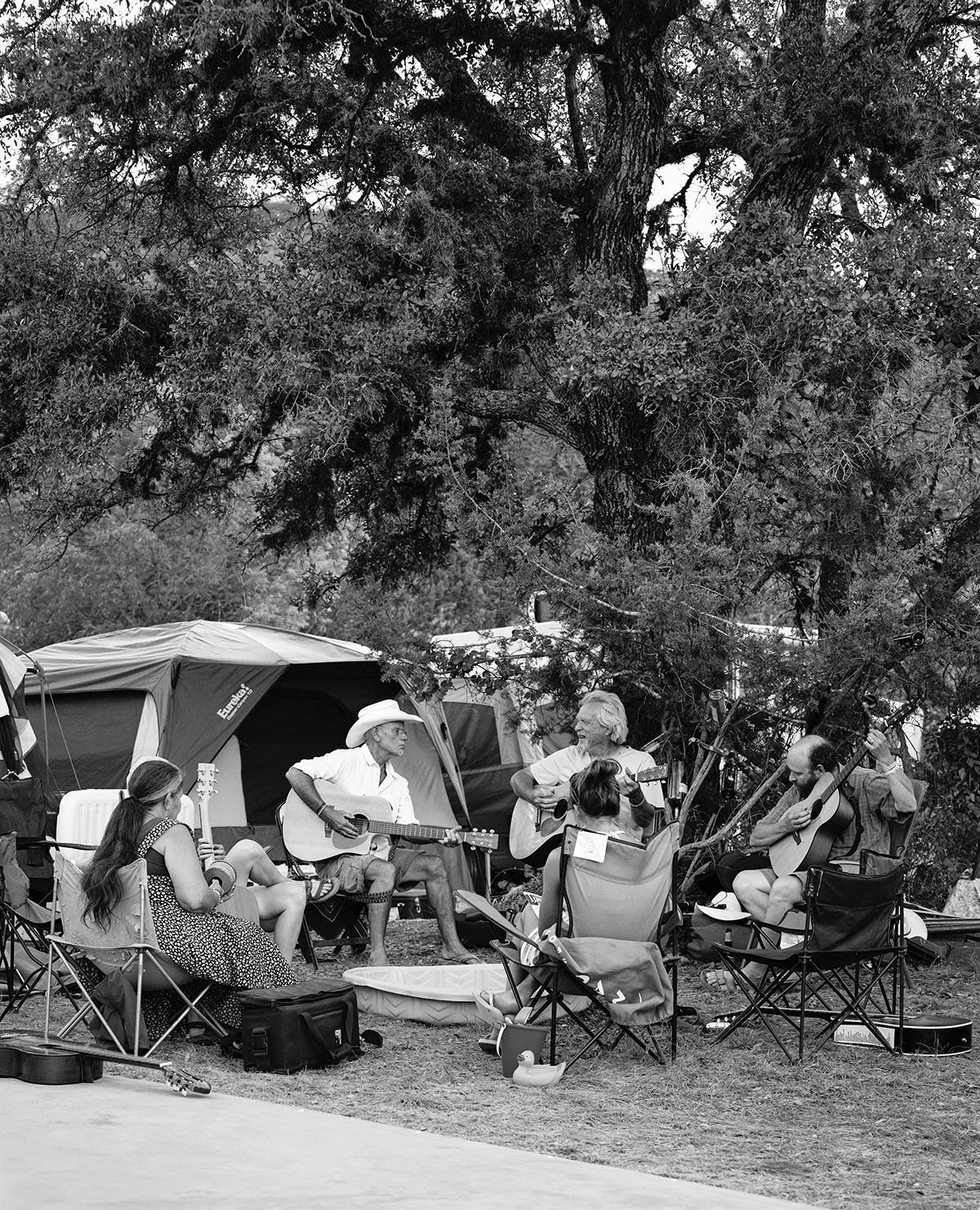 A group of people sit in a circlee making songs