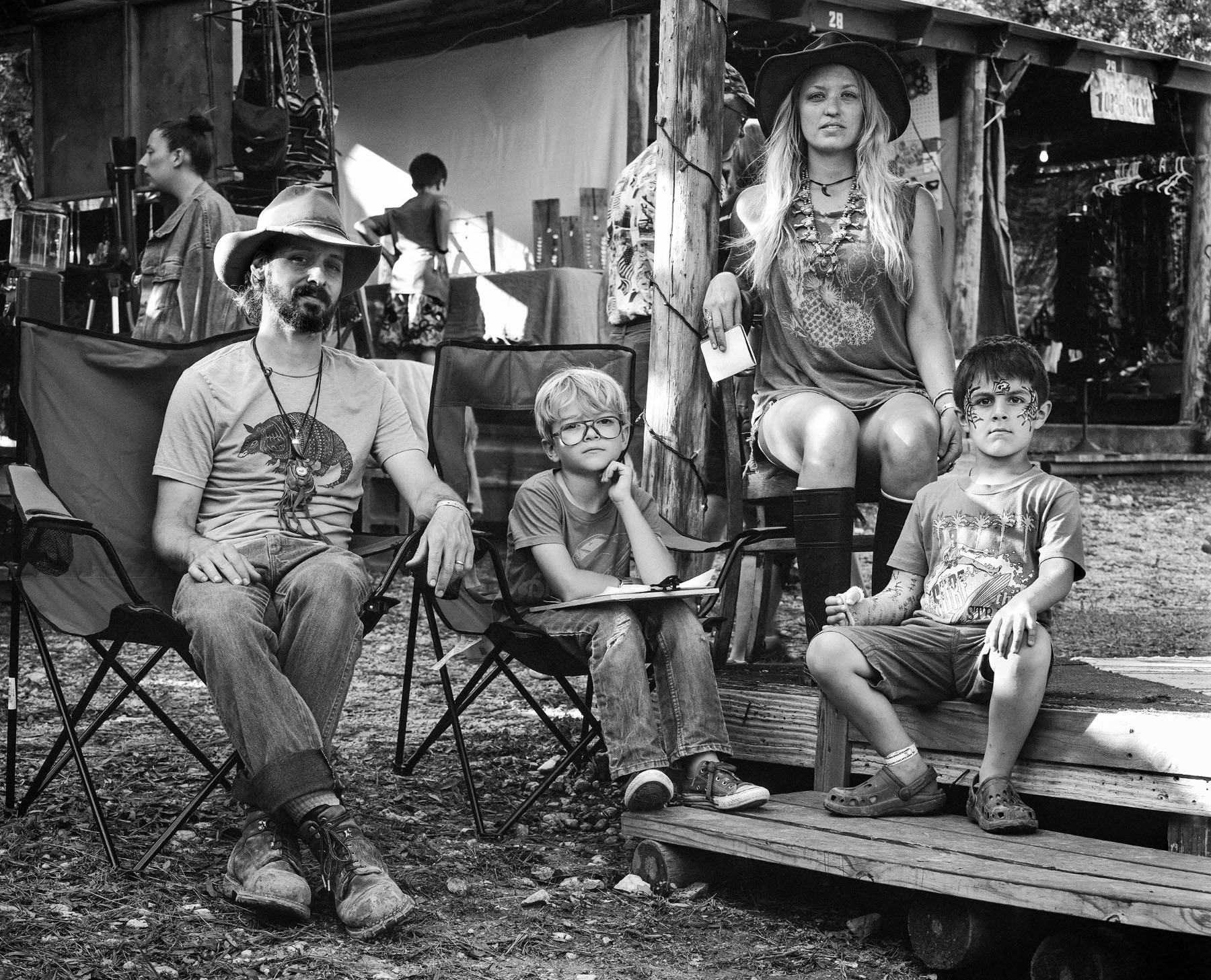 A group of people with two young children sit in folding chairs