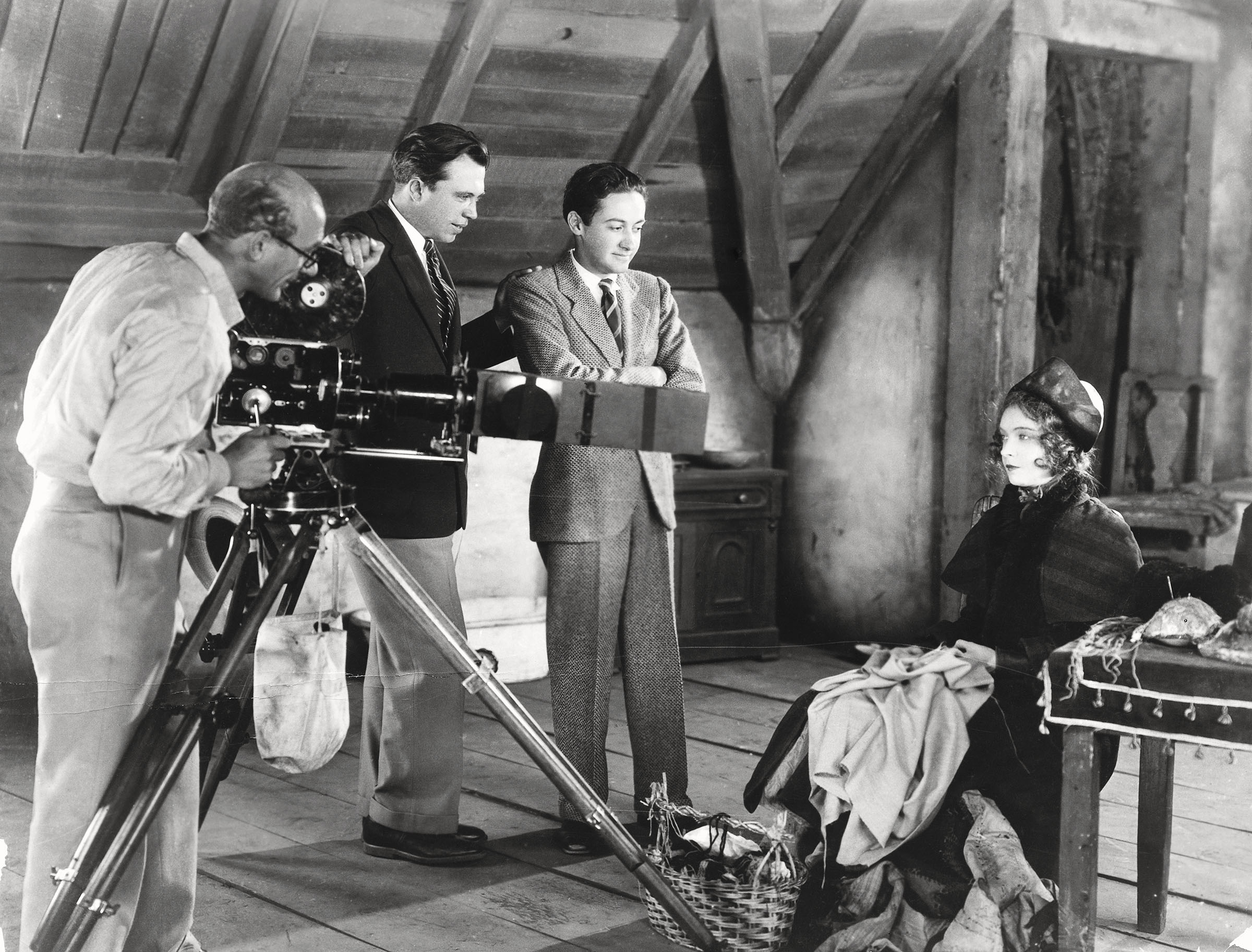 A black and white photo of a group of people standing on a film set