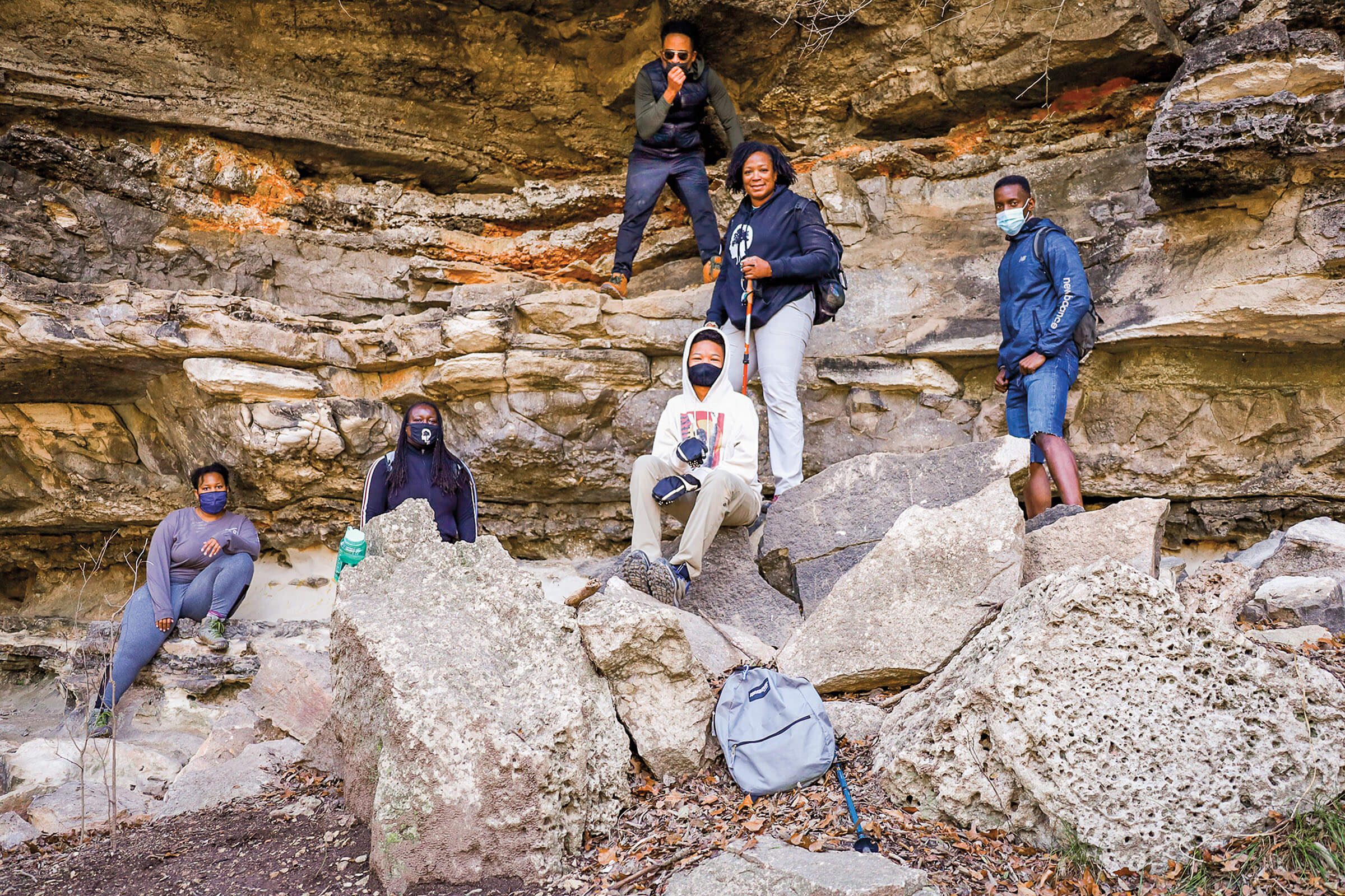 A group of hikers stand among rocks and boulders