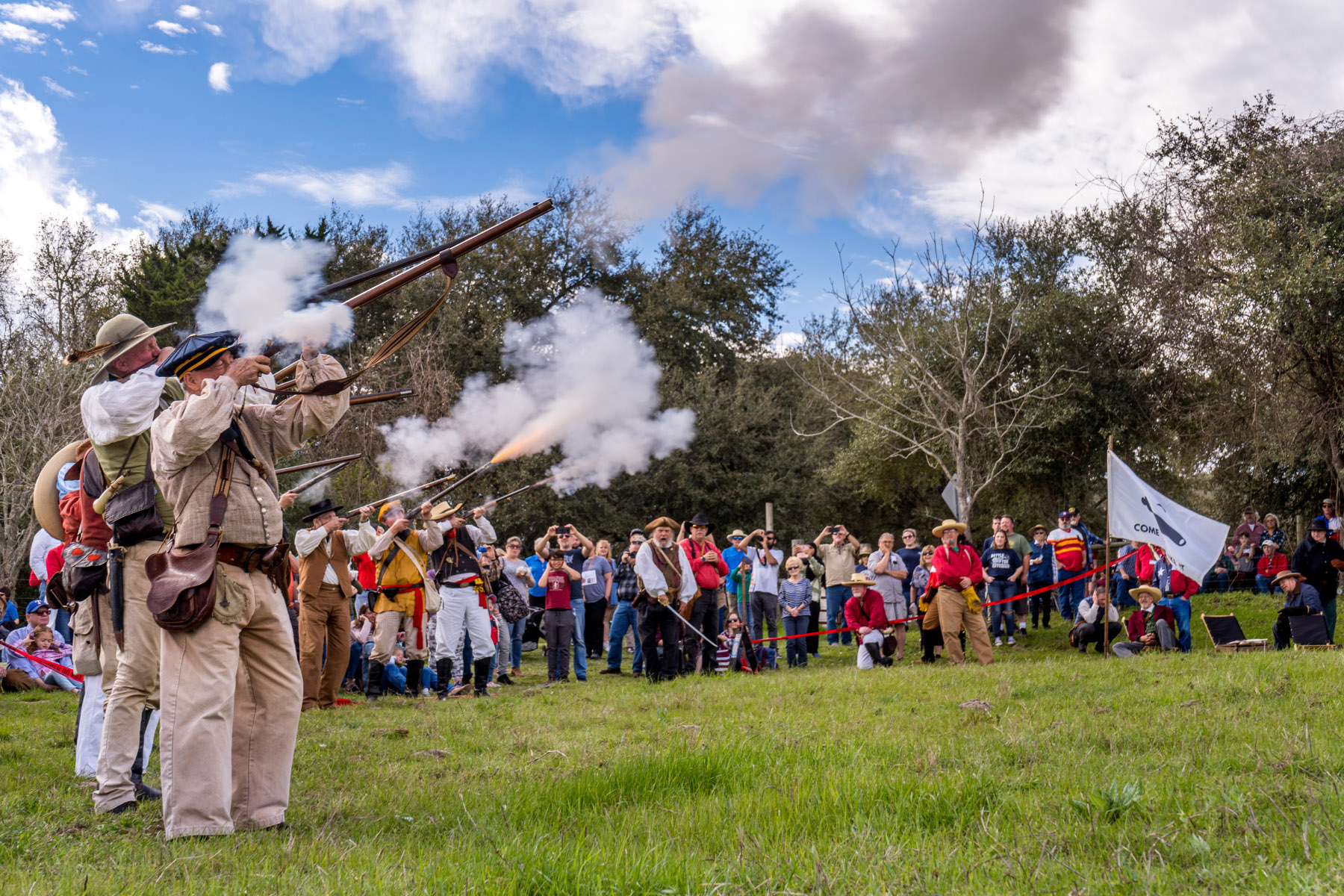 A group of people watch as a few male re-enactors fire old rifles during a Texas Independence Day Celebration at Washington-on-the-Brazos Historic Site. Photo by Will van Overbeek.