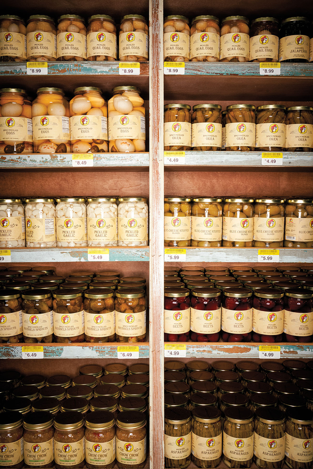 A wall of jarred, pickled foods including eggs, garlic, olives and beets