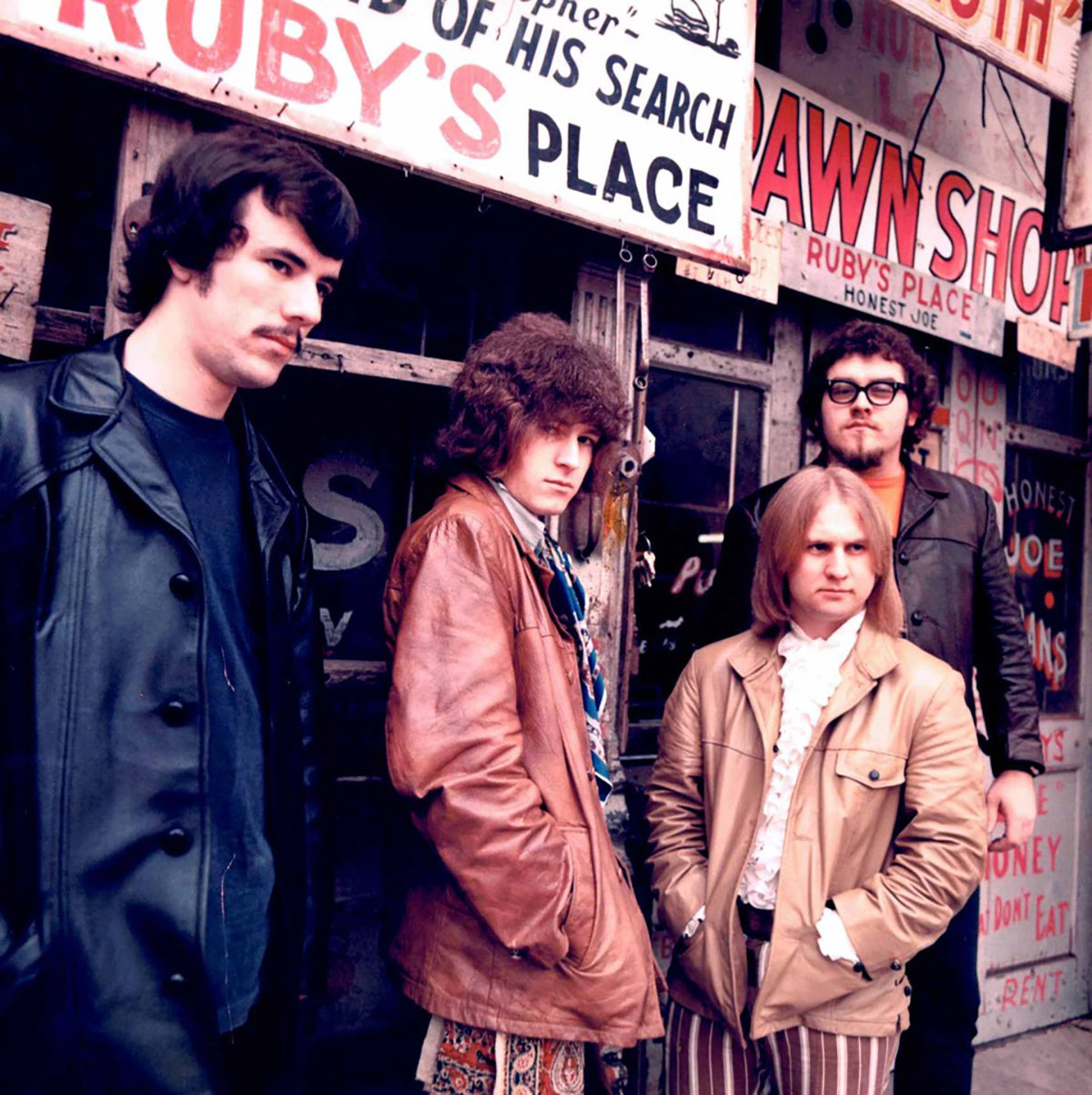 A group of people in jackets stand outside of a club