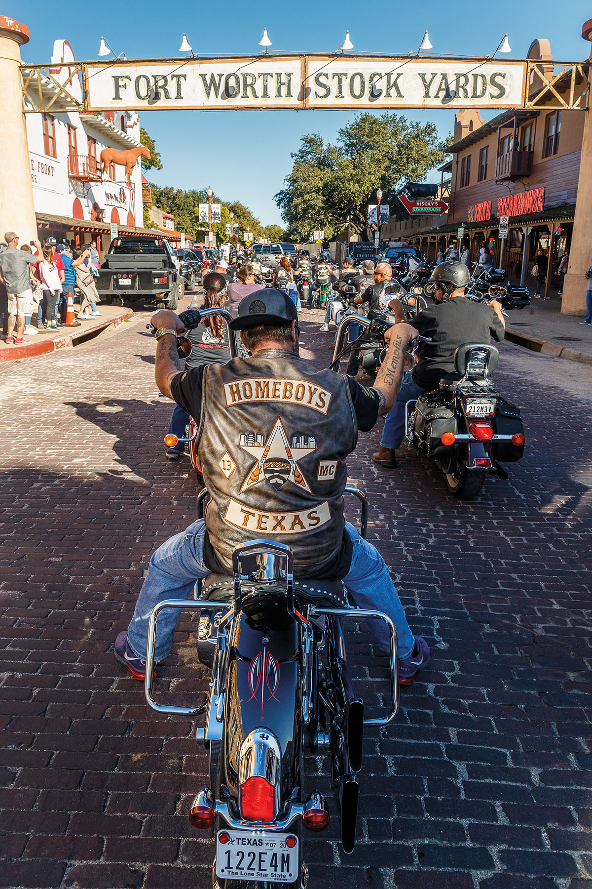 A group of motorcyclists under a banner reading "Fort Worth Stock Yards"