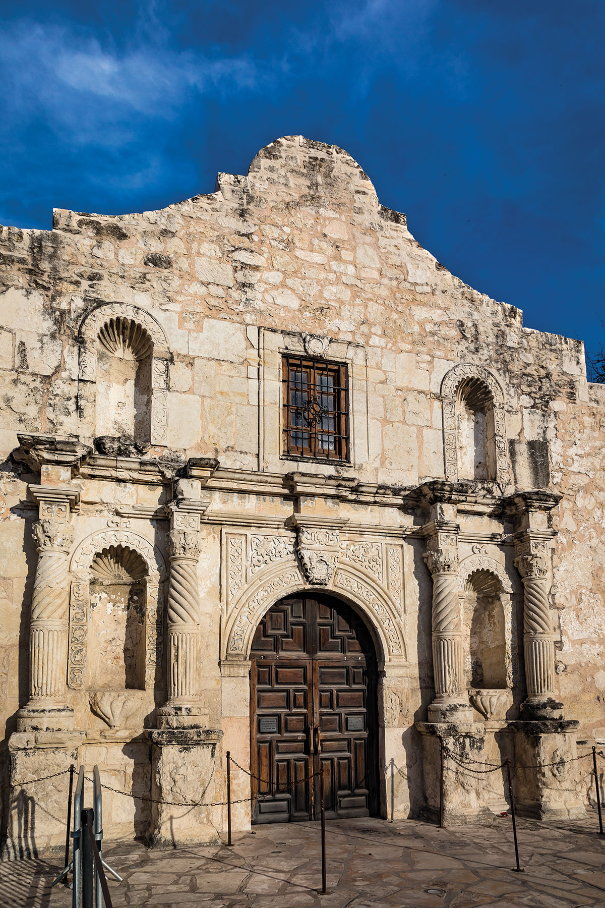 The stone facade of the Alamo under a blue sky