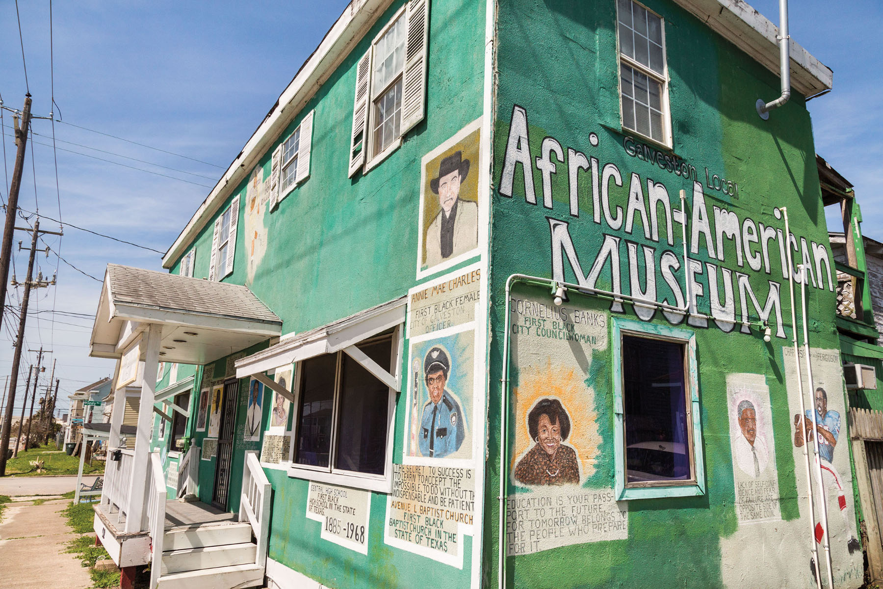 A green building reading "African-American Museum" on the side with small painted portraits