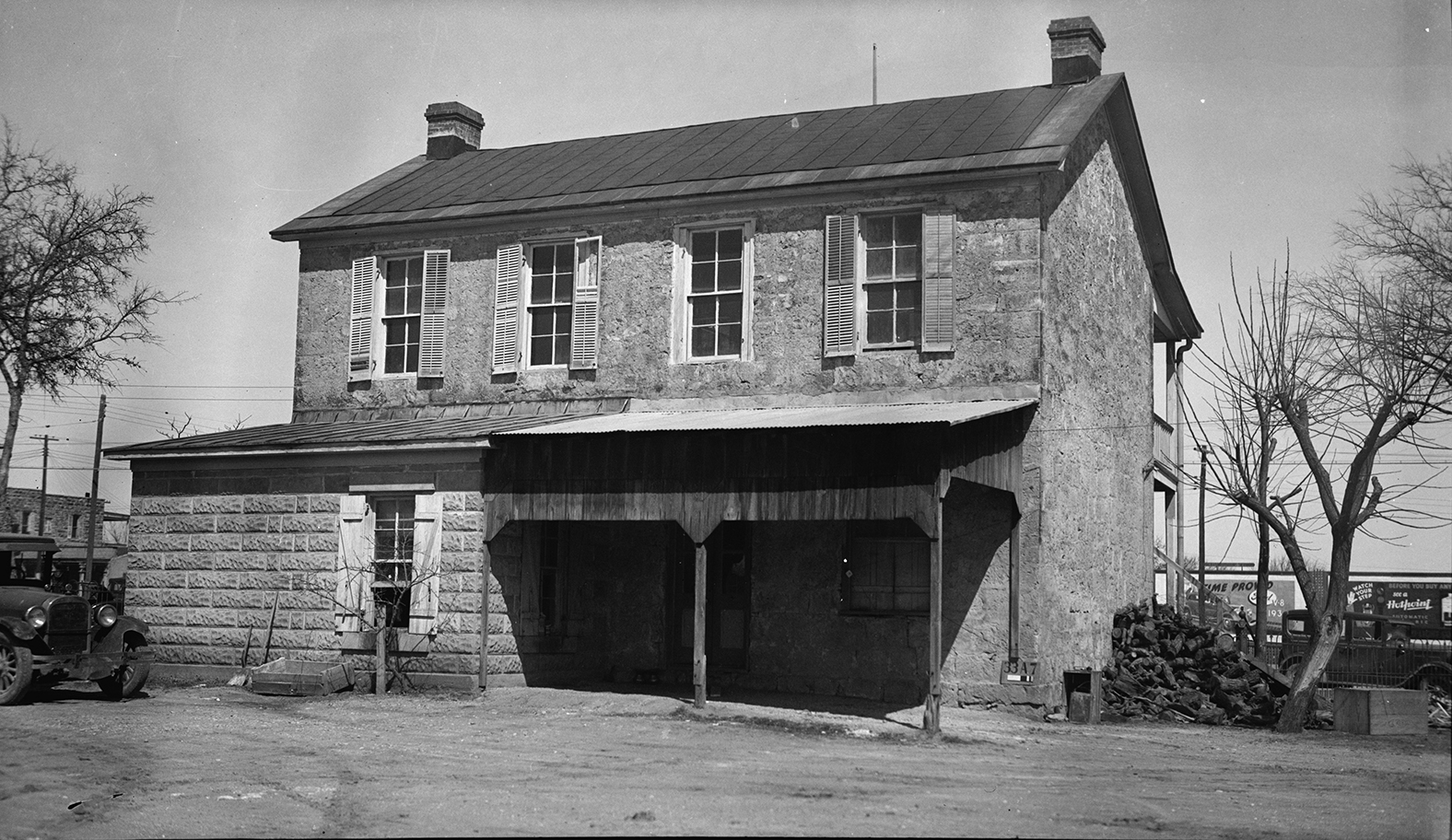 The outside of a stone building with a dark metal roof