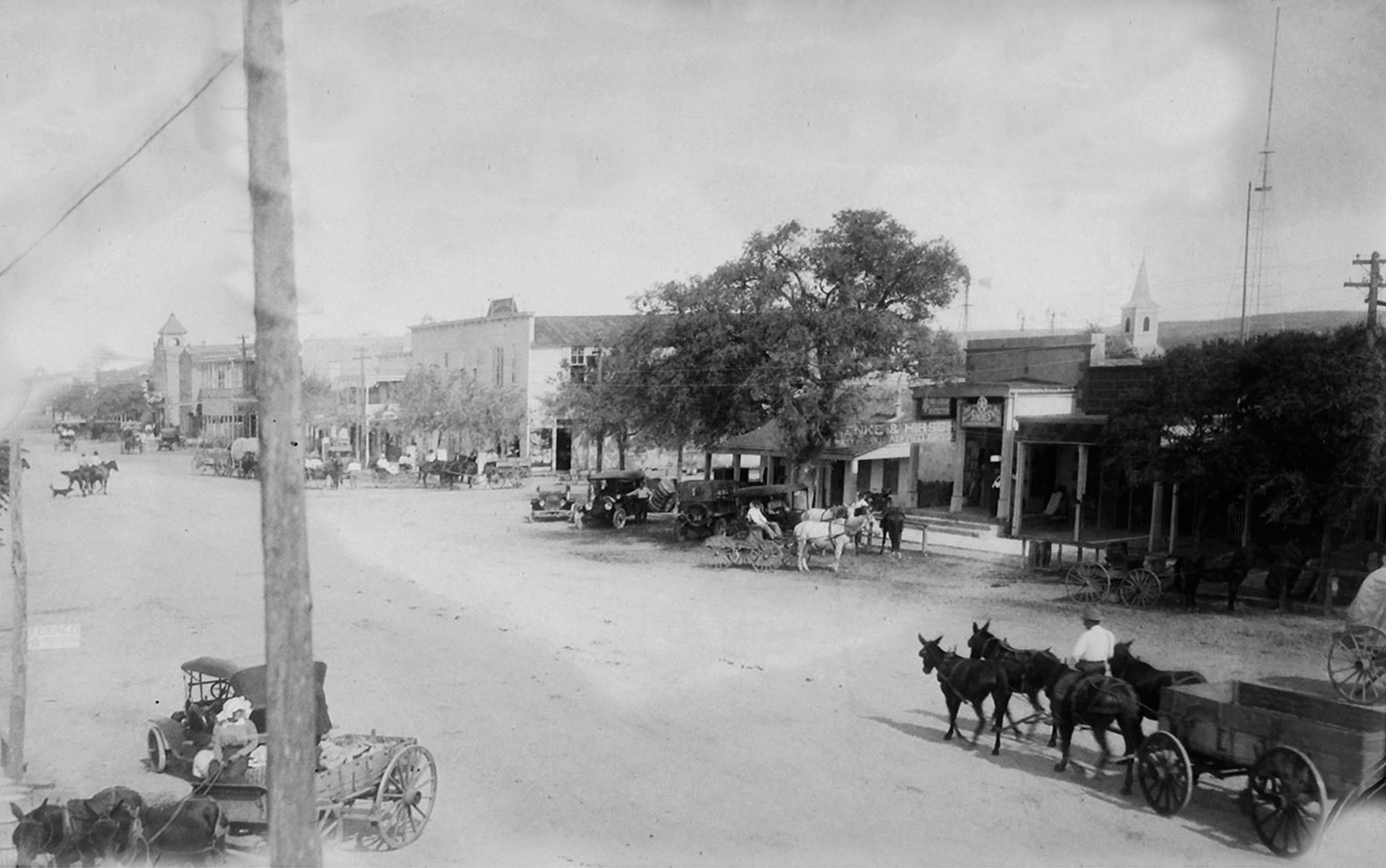 An overhead view of wagons and horses along a dirt street