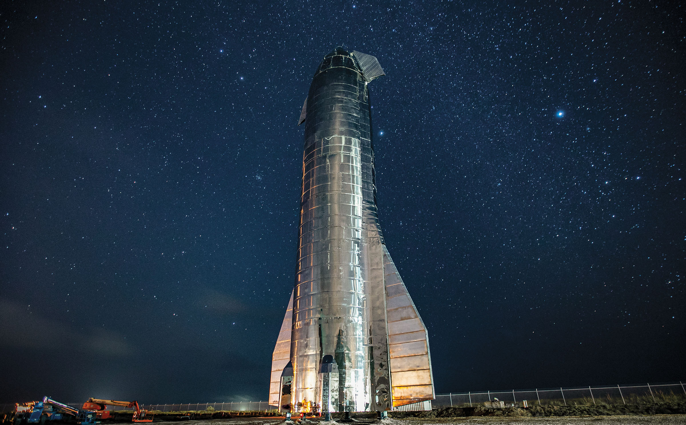 A bright silver rocket in front of a starry night sky