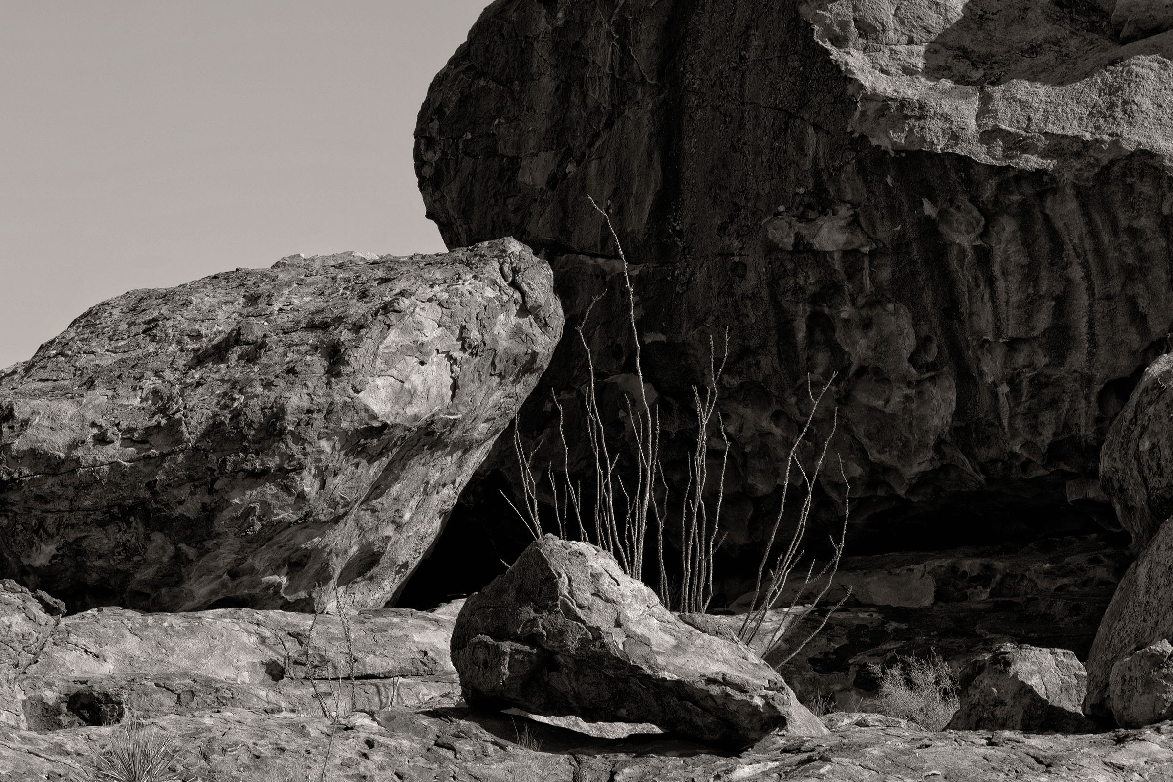 A black and white photo of boulders in a desert scene