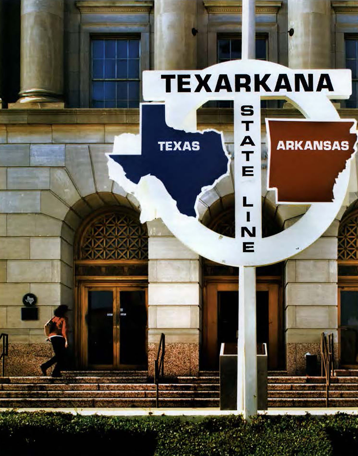 Photo of a white sign in front of Texarkana's courthouse and post office
