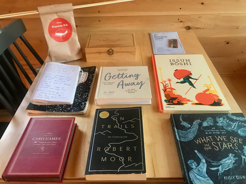 Arranged on top of a table, a selection of books offered in a cabin at Getaway Wimberley. Photo by Clayton Maxwell. 