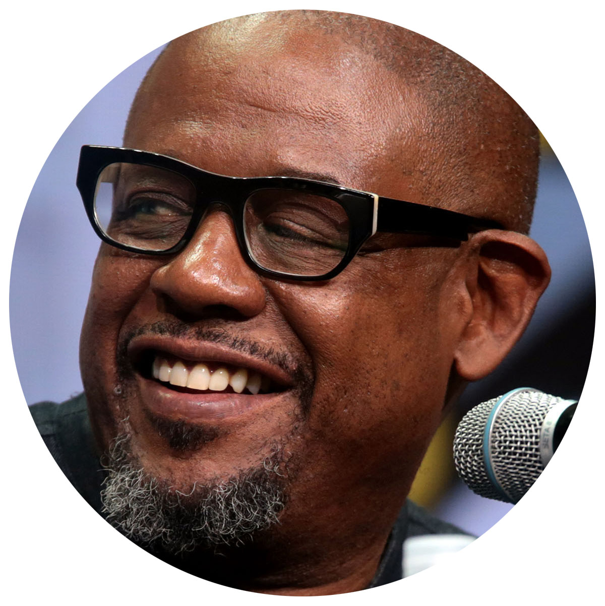 A picture of Forest Whitaker smiling in black glasses