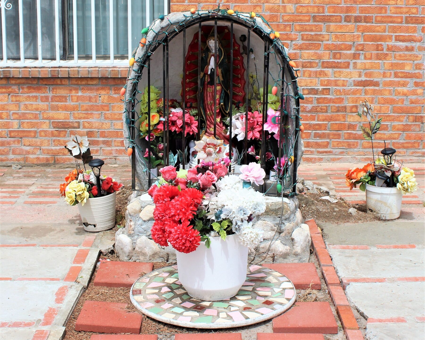 Color photo of female figurine behind bars with flowers
