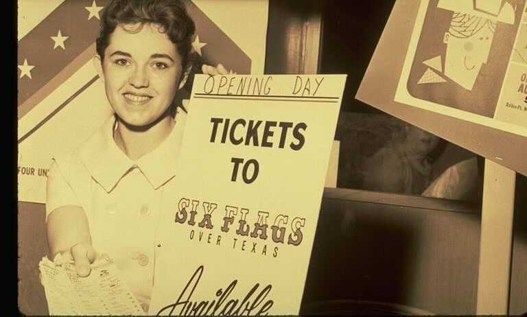 A young woman holds a sign that reads "Tickets to Six Flags" on the opening day of the park in 1961. Photo courtesy Six Flags Over Texas.